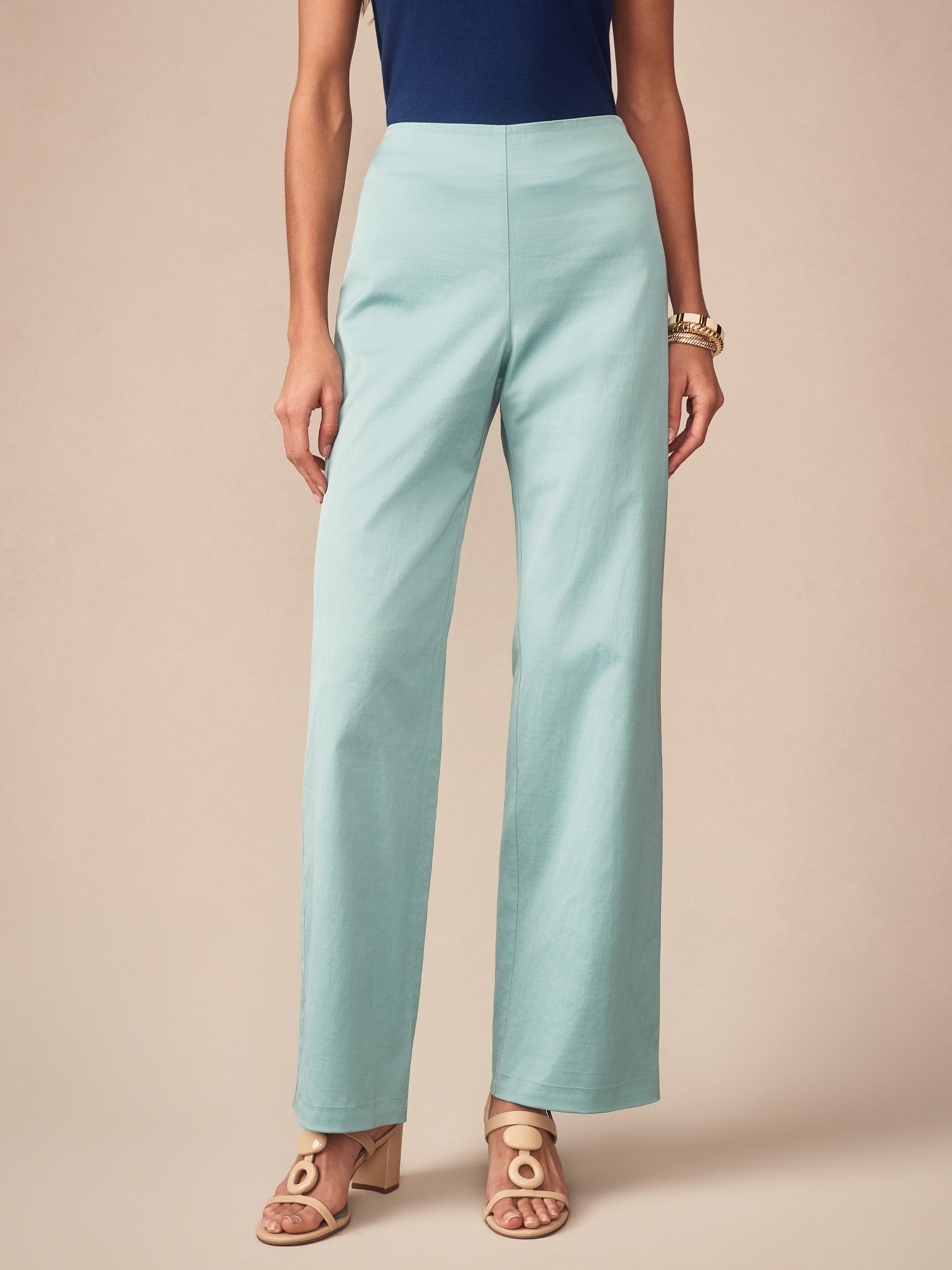 Woman wearing seafoam green Carter Dupioni Cotton Pants from J.McLaughlin paired with a navy top and stylish sandals, showcasing effortlessly stylish, enduring designs and innovative fabrics.