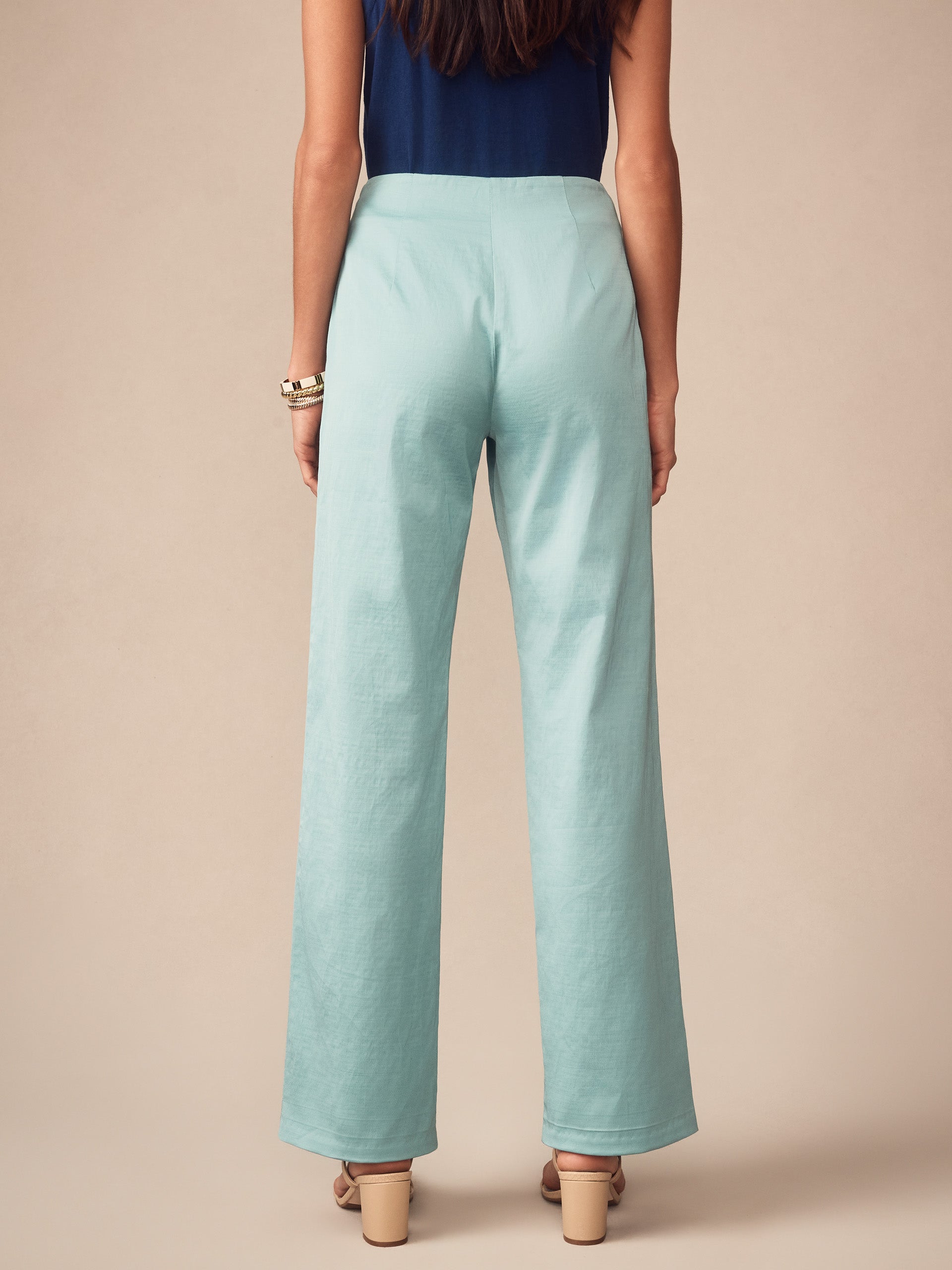 Woman wearing seafoam green Carter Dupioni Cotton Pants by J.McLaughlin paired with a navy top and beige heeled sandals, showcasing effortlessly stylish, enduring designs with innovative fabrics.