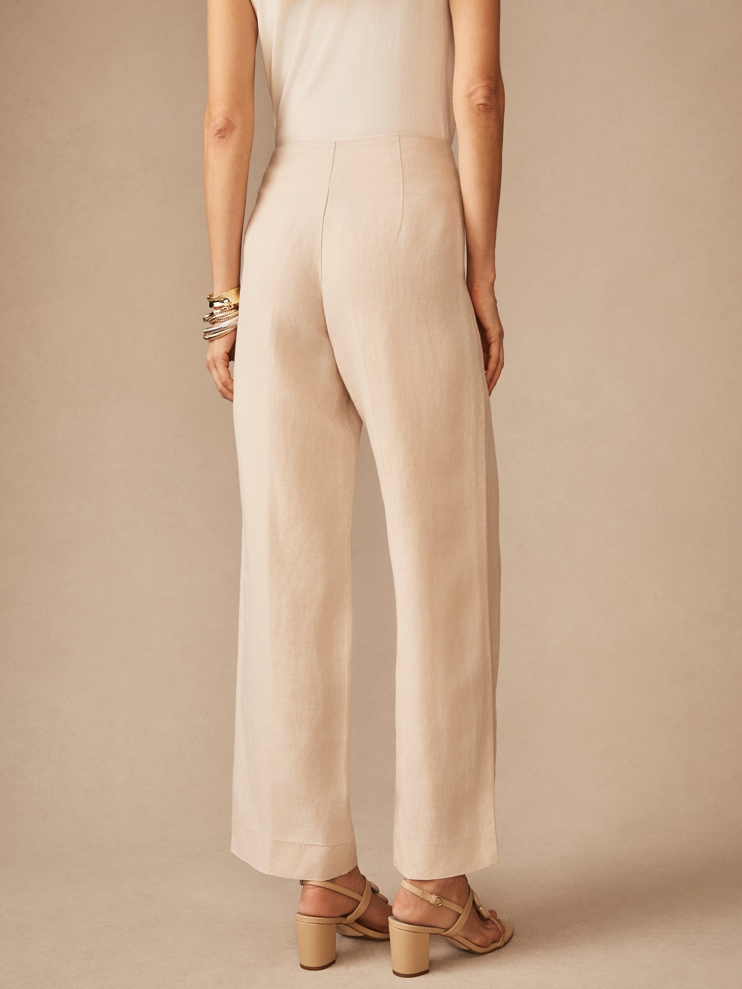 A woman modeling Carter Linen Pants by J.McLaughlin in a neutral tone, showcasing effortlessly stylish pants with enduring designs and a legacy of timeless fashion.
