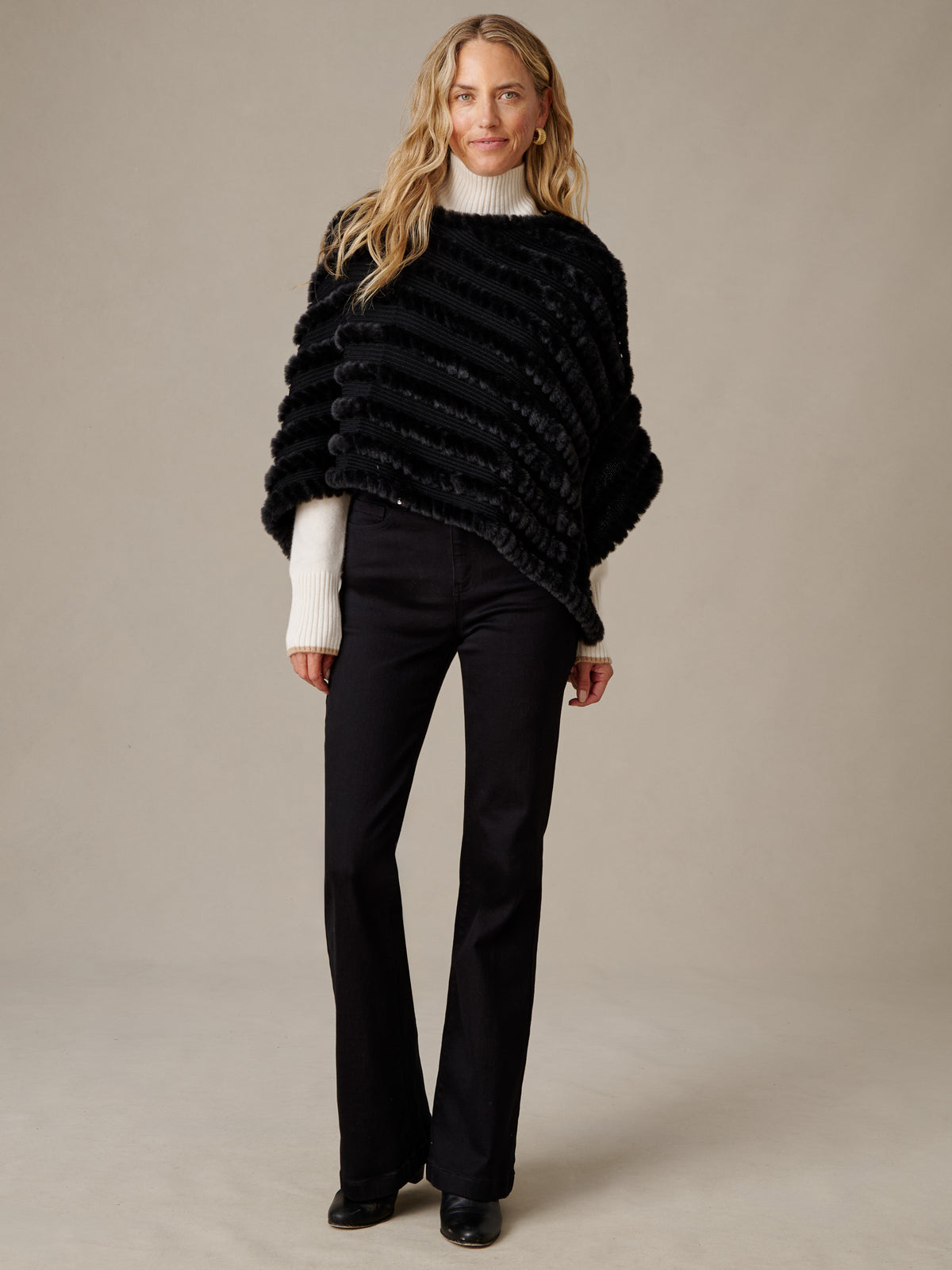 Charlie Faux Fur Poncho by J.McLaughlin in black faux fur styled with a white turtleneck and black pants for timeless winter elegance
