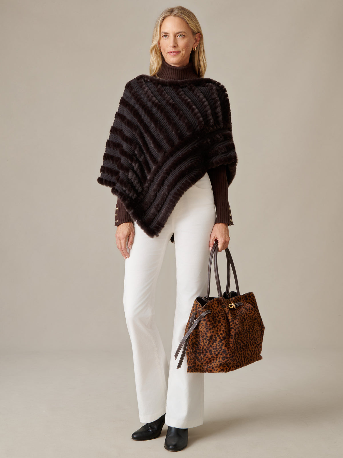J.McLaughlin Charlie Faux Fur Poncho in black styled with white pants and a leopard print tote