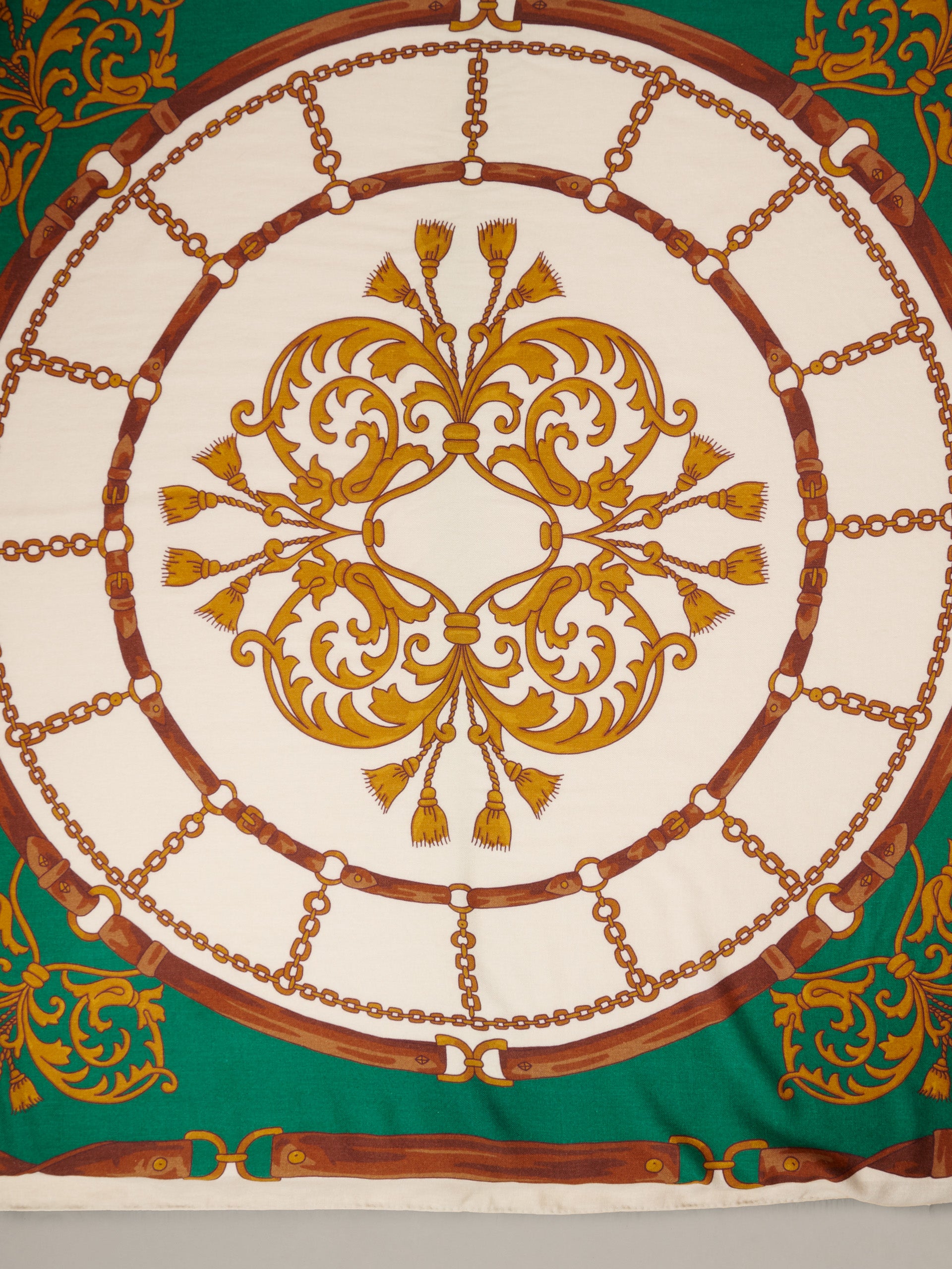 The Charlotte Scarf in Gilded Bridle Border by J.McLaughlin featuring an ornate gold and brown bridle motif on a cream and green background