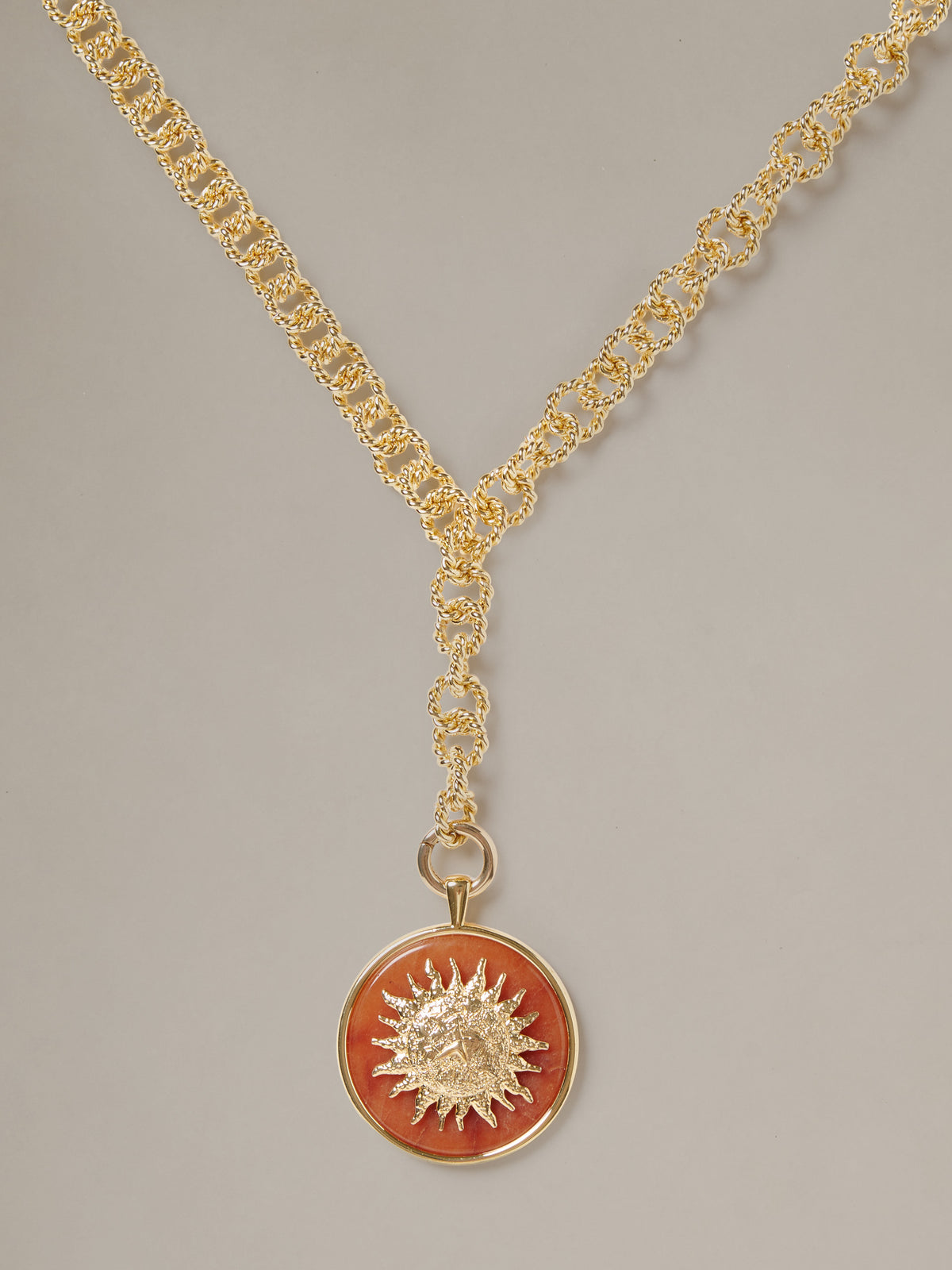 J.McLaughlin Charm Pendant Necklace featuring a gold chain and round red sunburst pendant with timeless appeal