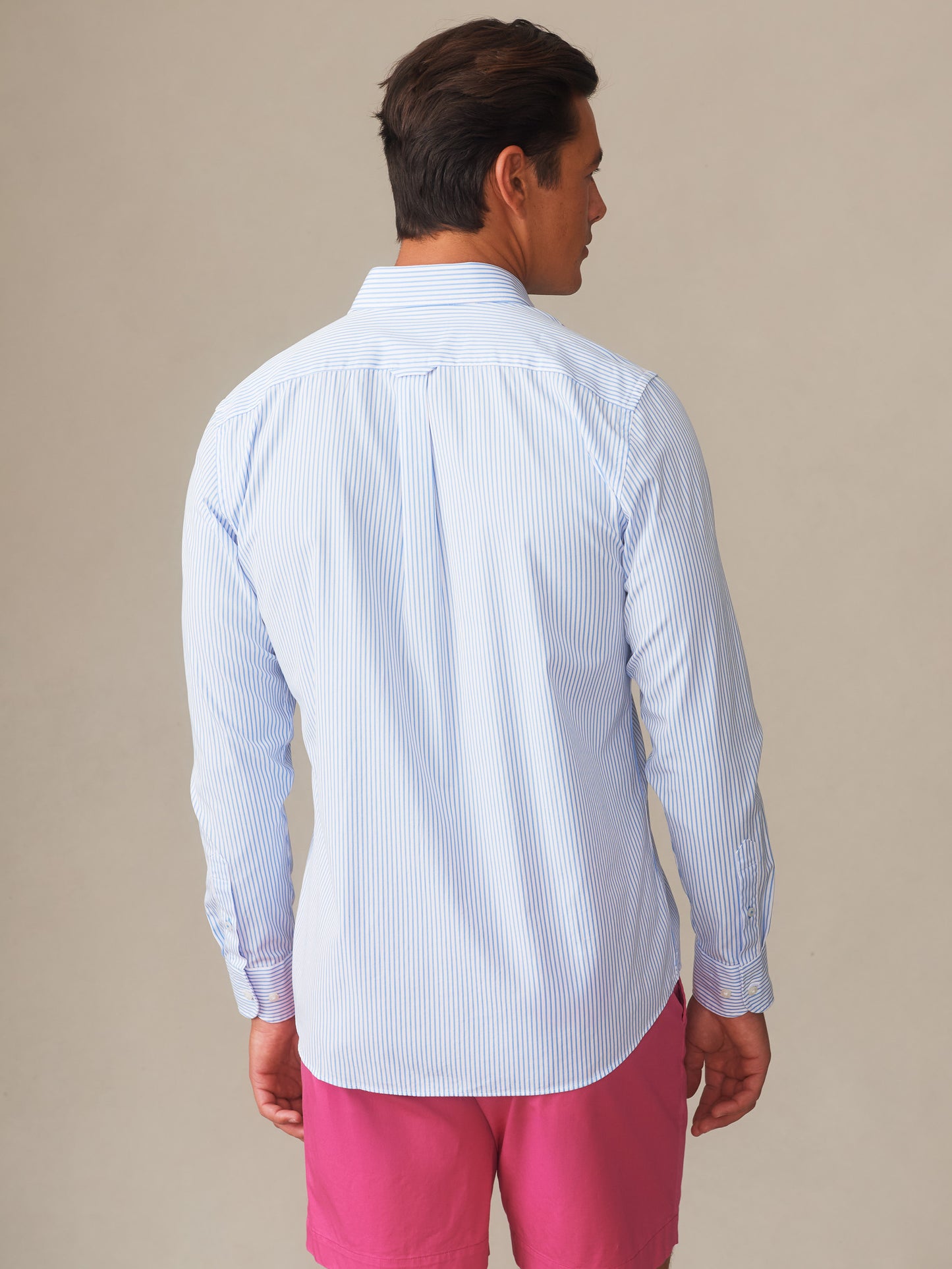 A man models the Gramercy Cotton Shirt in Pencil Stripe by J.McLaughlin, showcasing effortlessly stylish, enduring designs crafted with innovative fabrics for a legacy of timeless fashion.