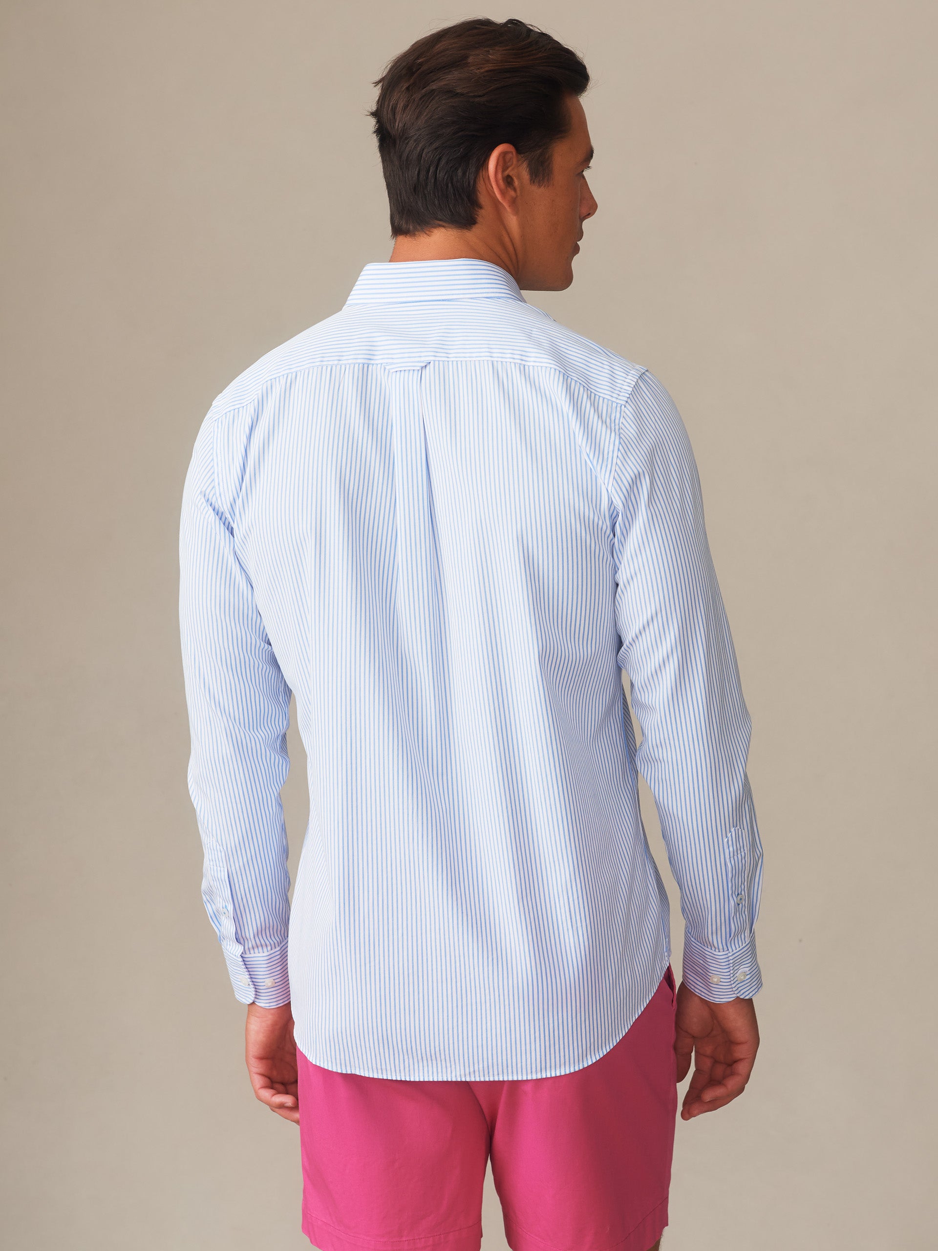 A man models the Gramercy Cotton Shirt in Pencil Stripe by J.McLaughlin, showcasing effortlessly stylish, enduring designs crafted with innovative fabrics for a legacy of timeless fashion.