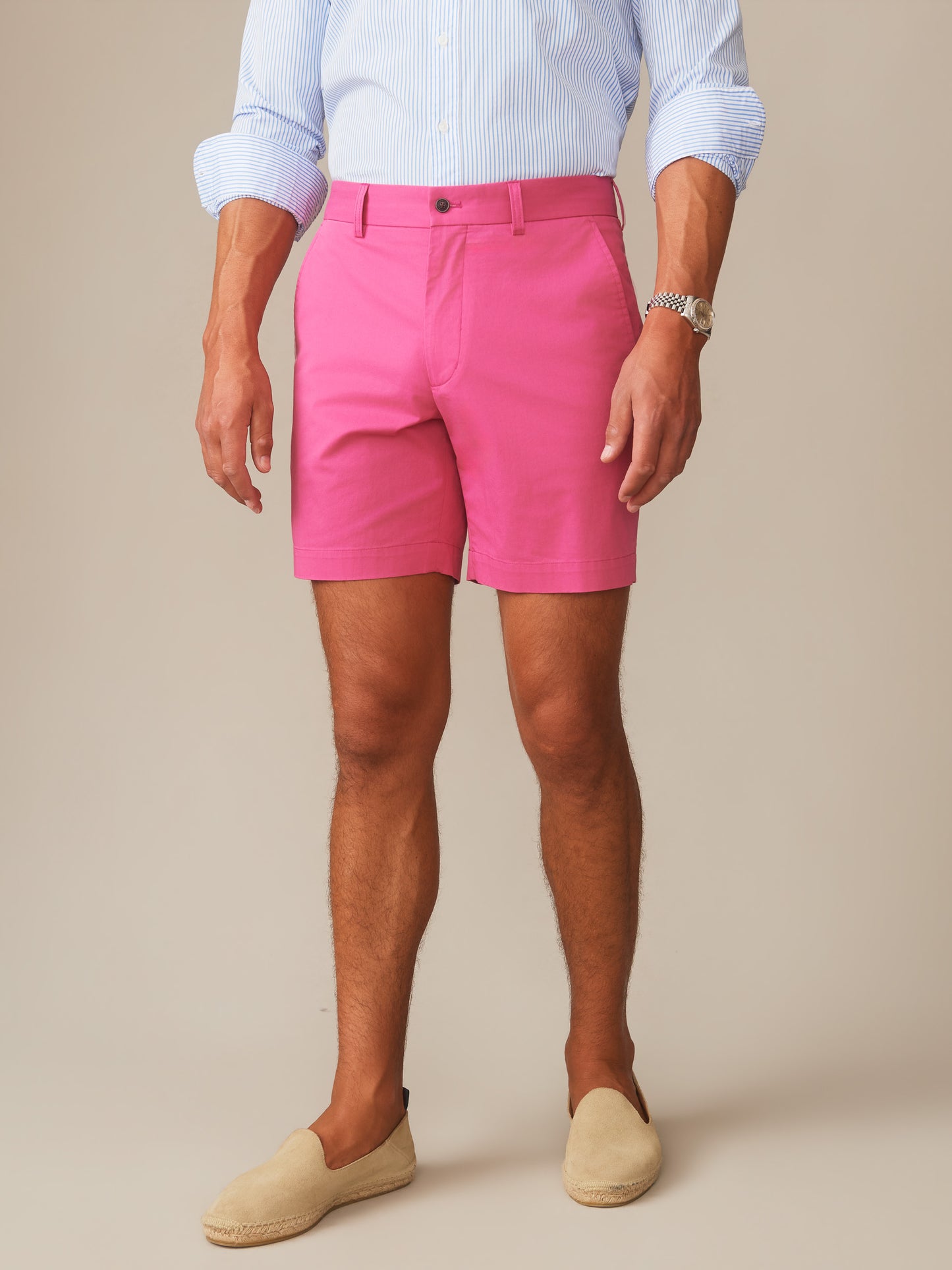 Man wearing hot pink Chatham Shorts by J.McLaughlin paired with a light blue striped shirt and beige espadrilles, showcasing effortlessly stylish, enduring designs for a life well-lived.