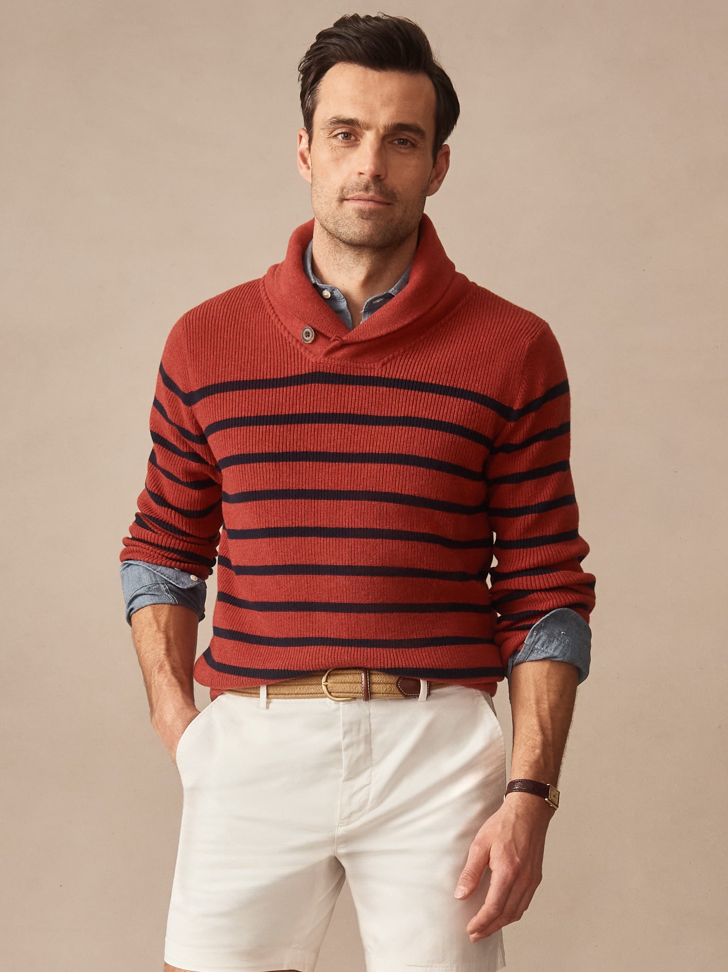 A man wearing a red and navy Hudson Sweater in Stripe layered over a blue shirt paired with white shorts and a tan belt, showcasing J.McLaughlin's effortlessly stylish, enduring designs and legacy of timeless fashion at a destination for defining style. Life, Well-Lived.