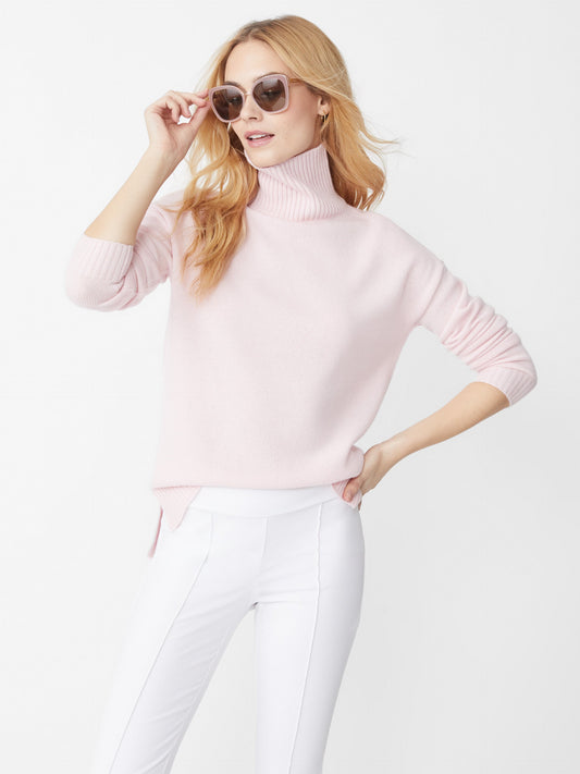 Model wearing J.McLaughlin Clara sweater in ice pink made with cashmere.