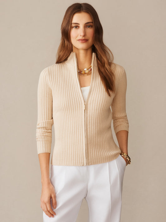 Woman wearing Clemence Zip Cardigan in oatmeal by J.McLaughlin, styled with white pants and layered necklaces, showcasing effortlessly stylish and enduring designs in a timeless look.