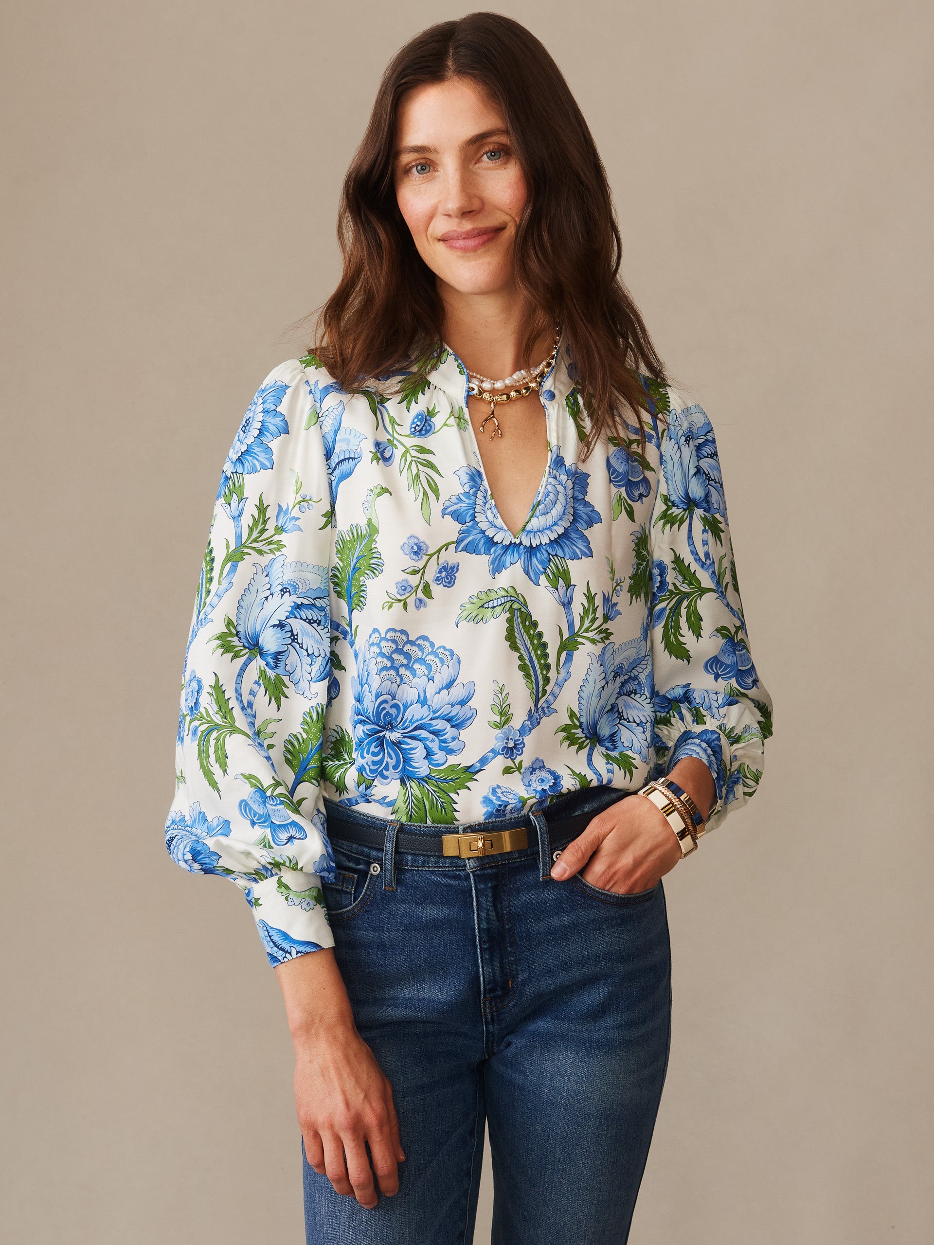 Woman wearing a Maeve Silk Blend Blouse in Cerulean Garden by J.McLaughlin, featuring an effortlessly stylish floral print in blue and green, paired with jeans, reflecting enduring designs and the legacy of timeless fashion at a destination for defining style. Life, Well-Lived.