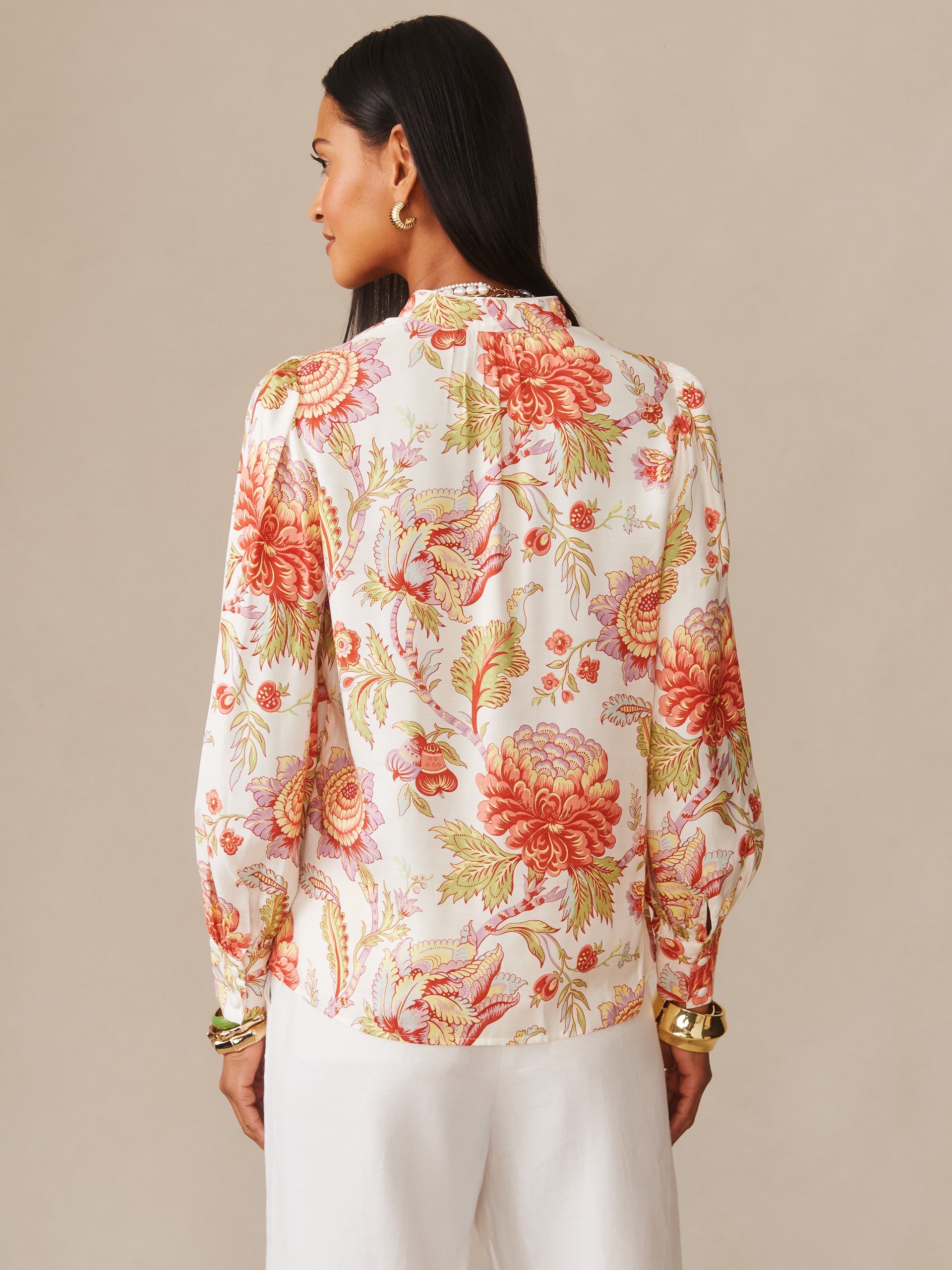 A woman seen from behind wearing the Maeve Silk Blend Blouse in Cerulean Garden by J.McLaughlin, featuring an effortless floral print in warm tones, embodying enduring designs and innovative fabrics from a destination for defining style. Life, Well-Lived.