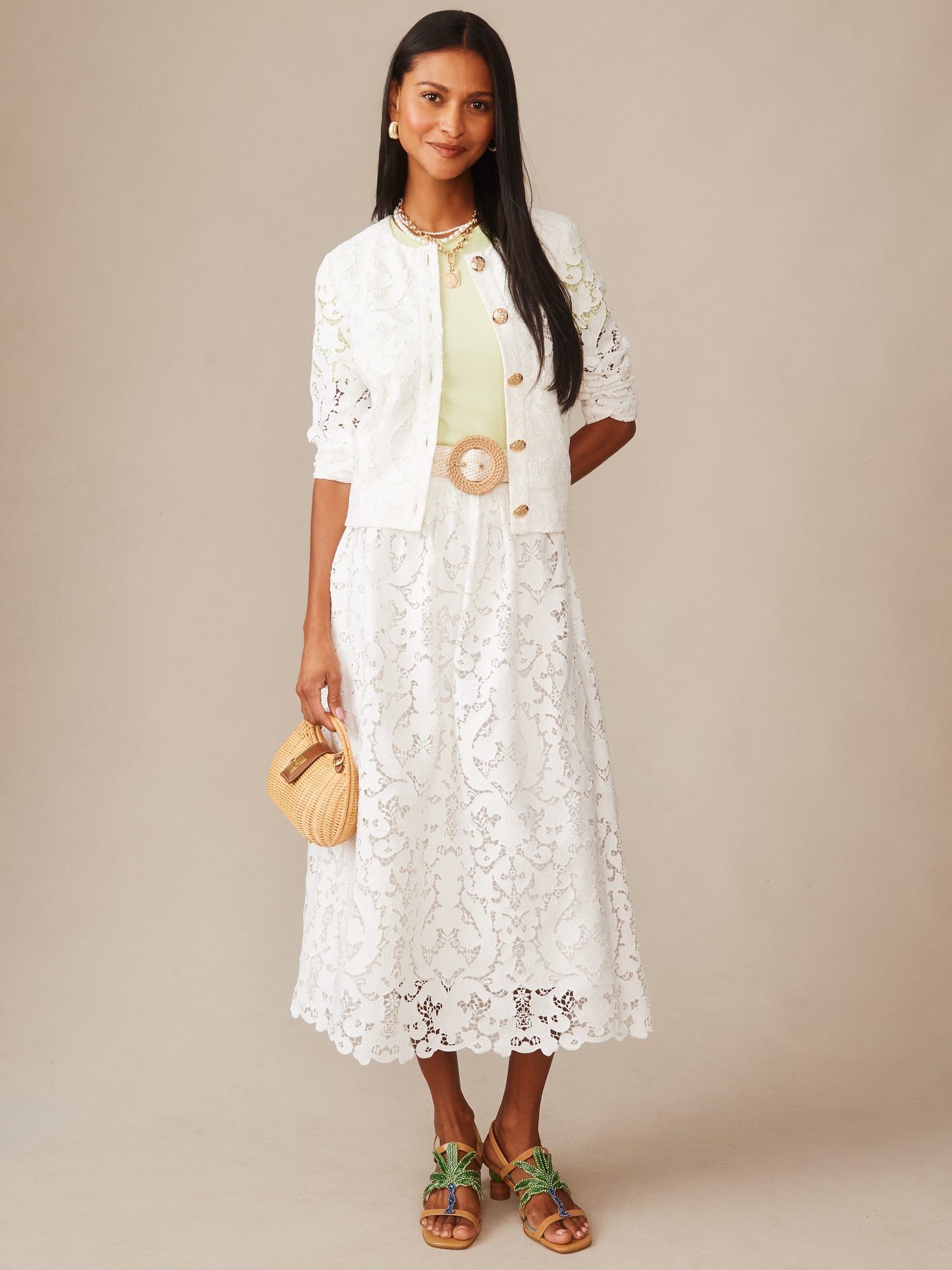 Woman wearing an off-white Coco Lace Jacket by J.McLaughlin paired with a matching lace skirt, featuring effortless style and enduring design, embodying a legacy of timeless fashion.