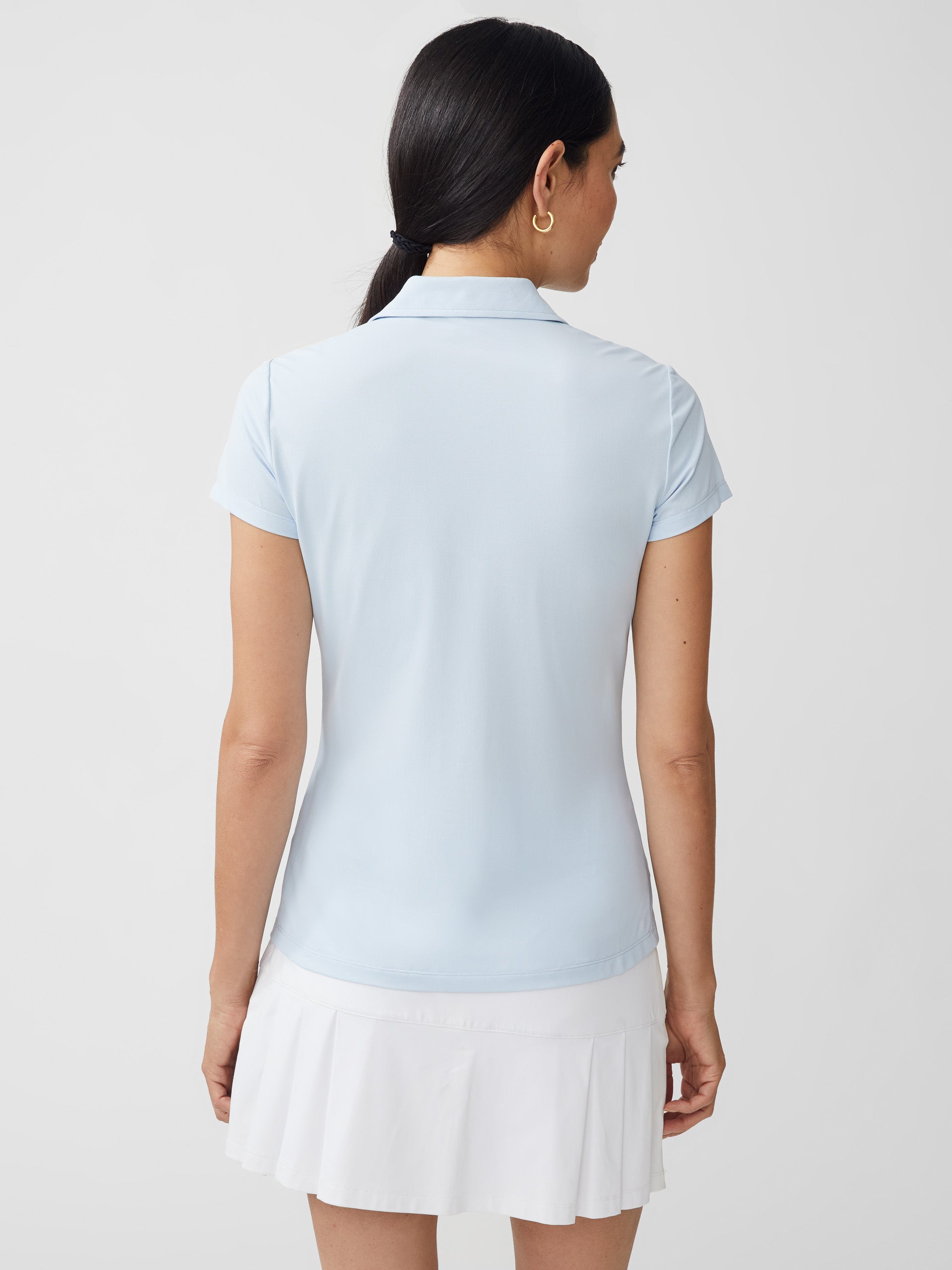 J.McLaughlin model wears Court Cap Sleeve Pique Polo in light blue made with Catalina Cloth.