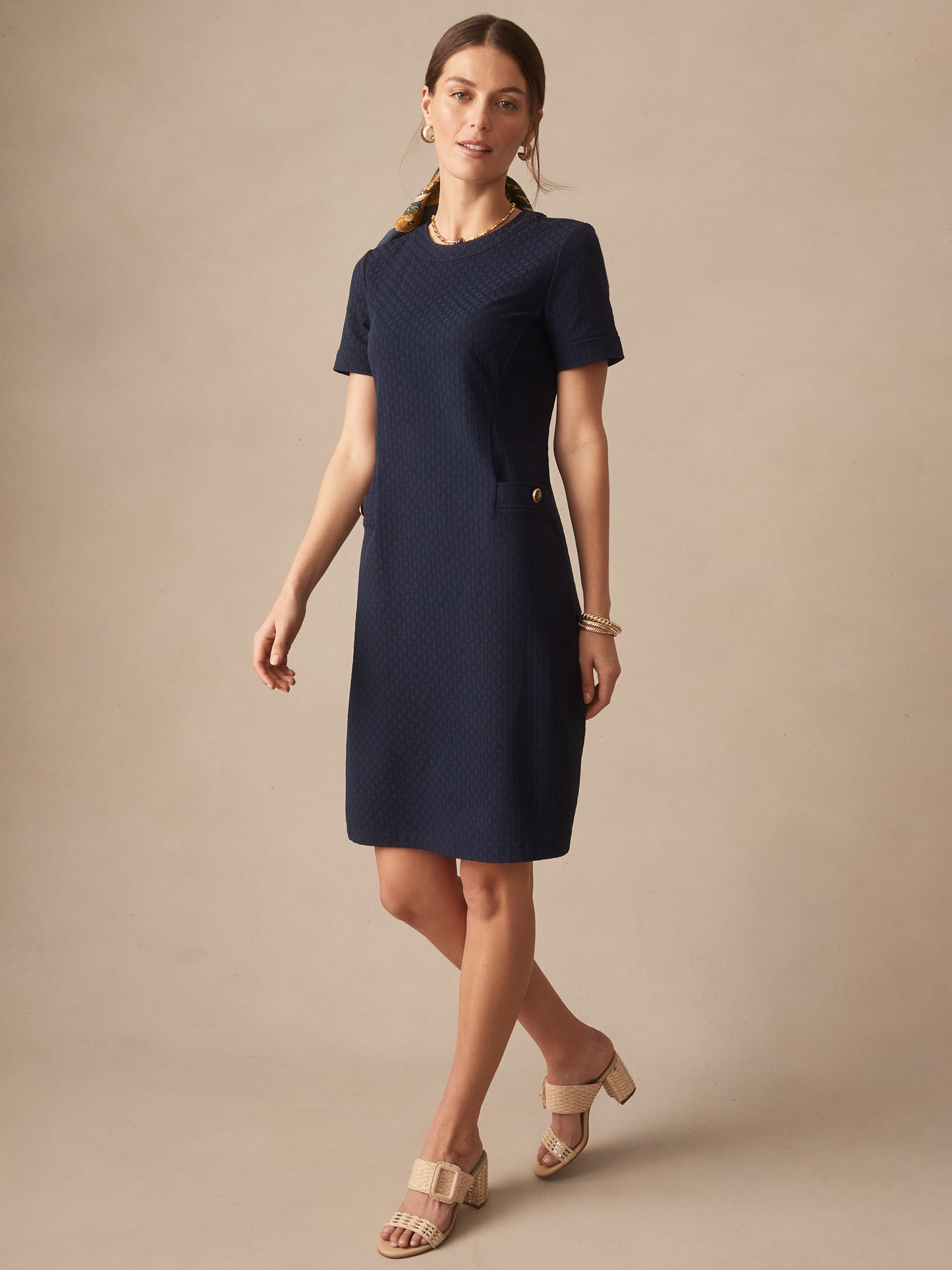 Woman wearing a navy Daphne Dress in Dashing Jacquard by J.McLaughlin, showcasing effortlessly stylish, enduring designs with innovative fabrics. A destination for defining style. Life, Well-Lived.