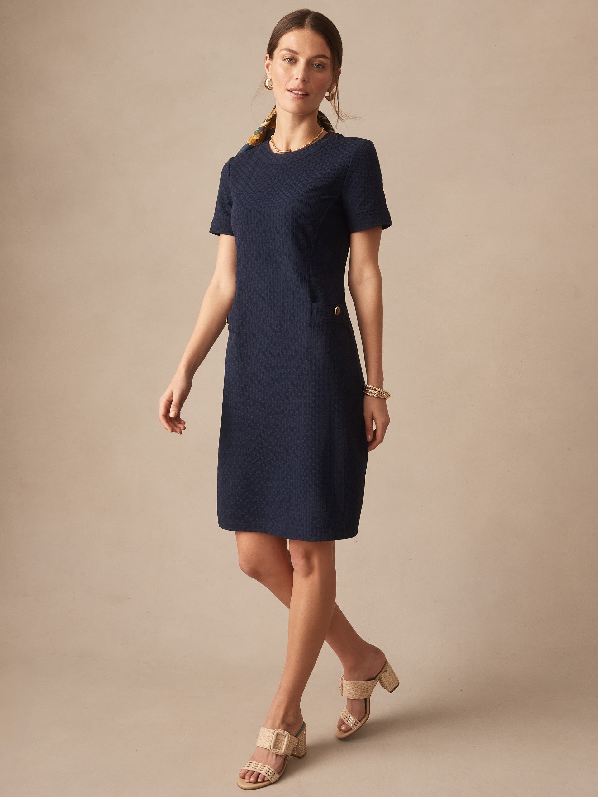 Woman wearing a navy Daphne Dress in Dashing Jacquard by J.McLaughlin, showcasing effortlessly stylish, enduring designs with innovative fabrics. A destination for defining style. Life, Well-Lived.