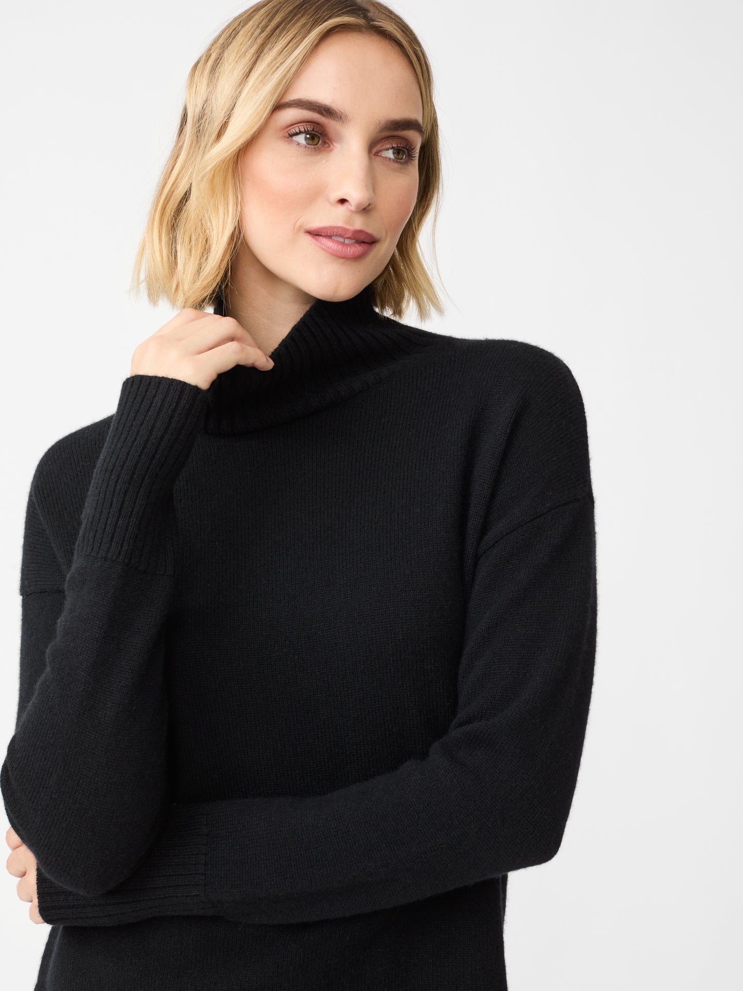 Model wearing J.McLaughlin Dina turtleneck in black made with cashmere.