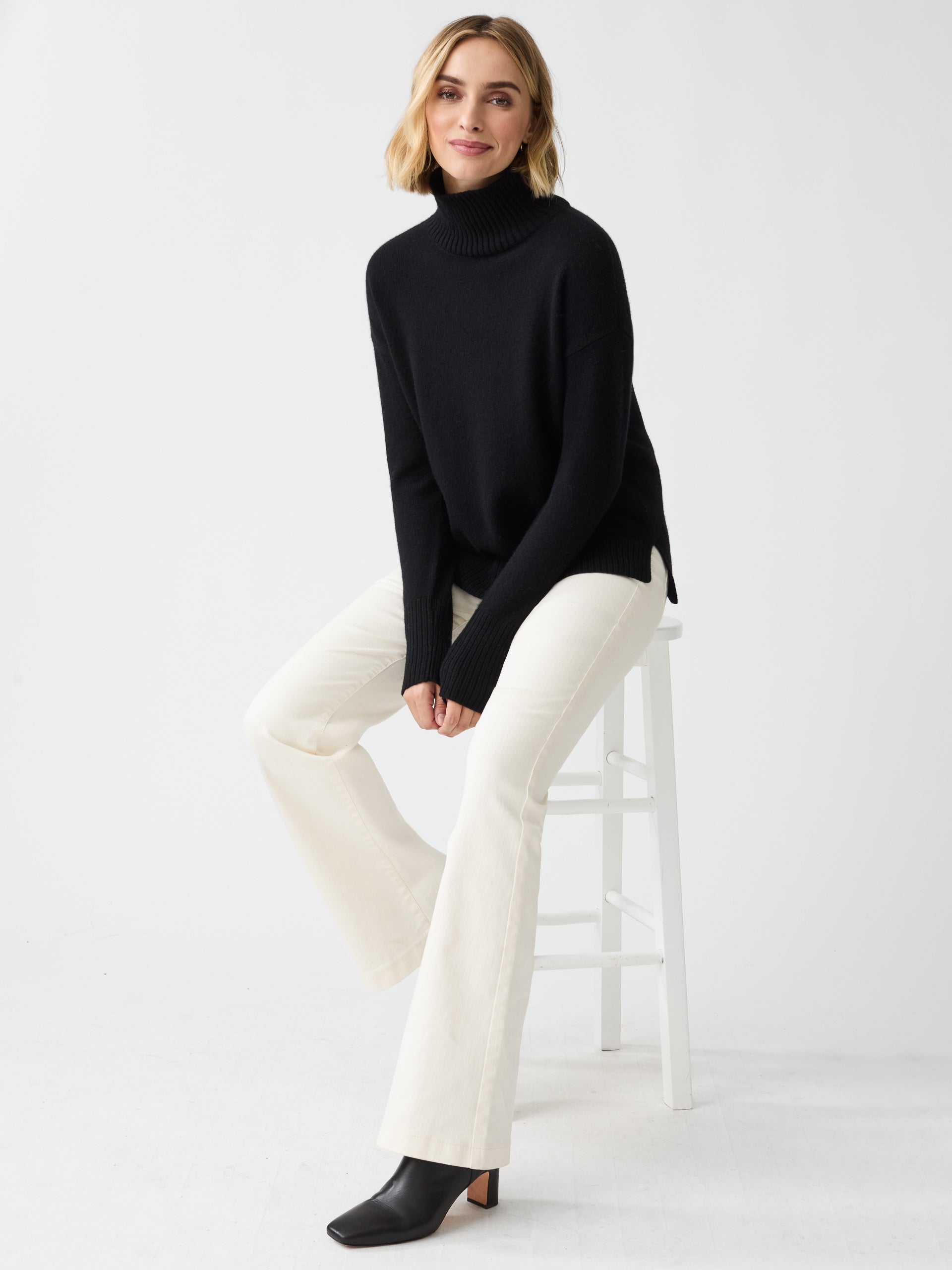 Model wearing J.McLaughlin Dina turtleneck in black made with cashmere.