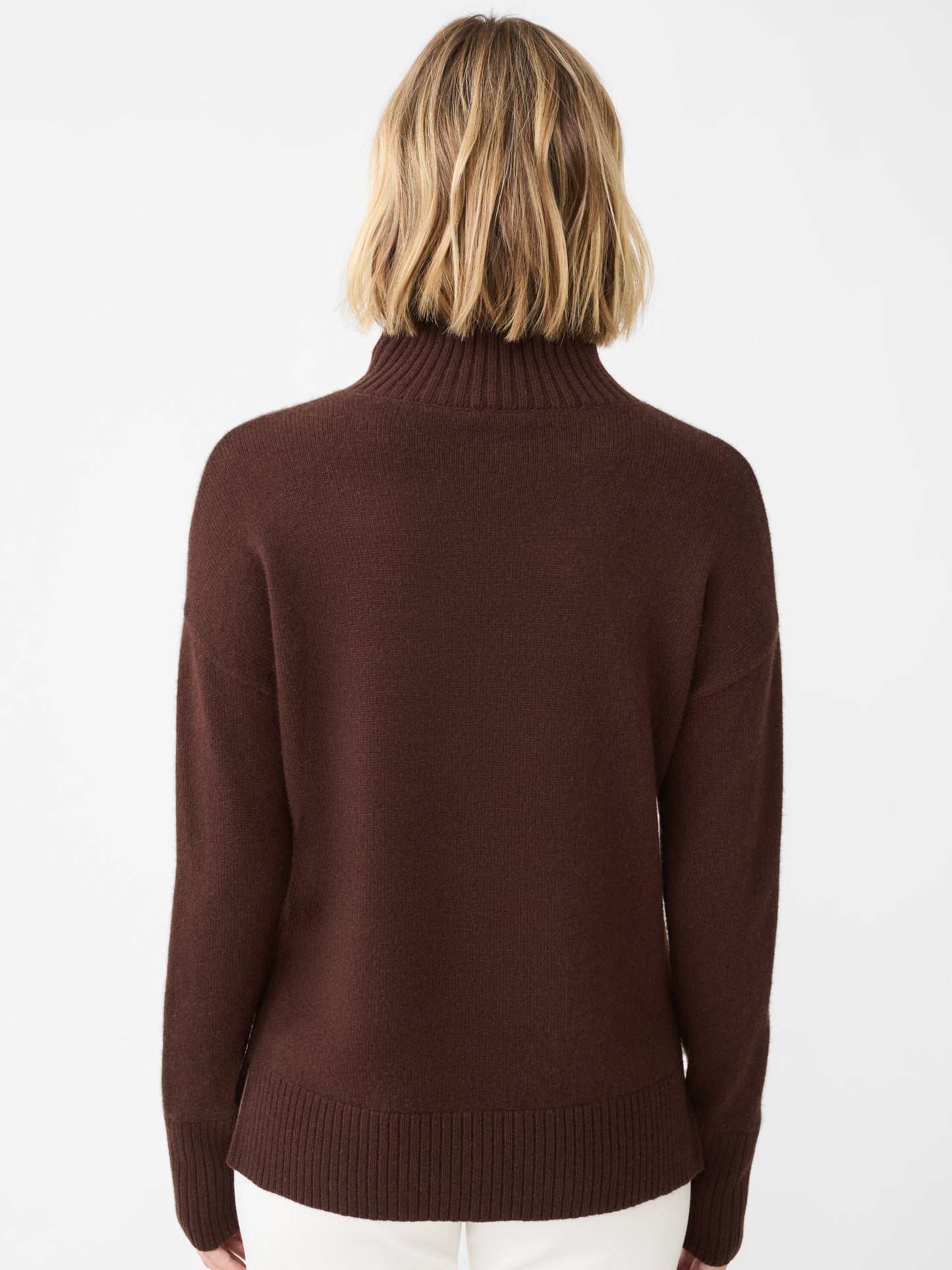 Model wearing J.McLaughlin Dina turtleneck in chocolate brown made with cashmere.