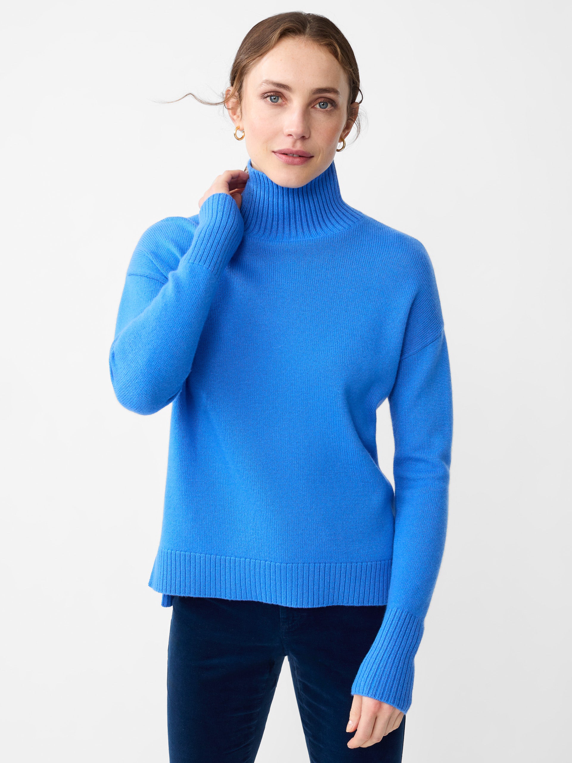 Model wearing J.McLaughlin Clara turtleneck in JMC blue made with cashmere.