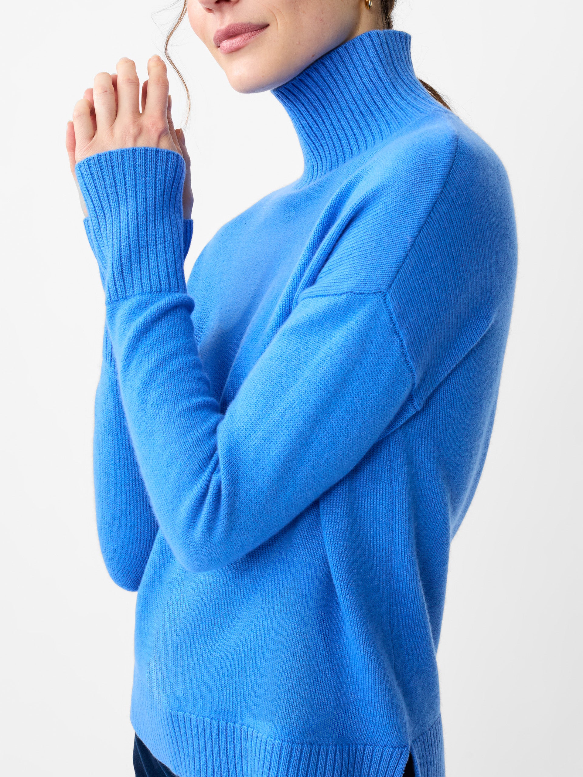 Model wearing J.McLaughlin Clara turtleneck in JMC blue made with cashmere.