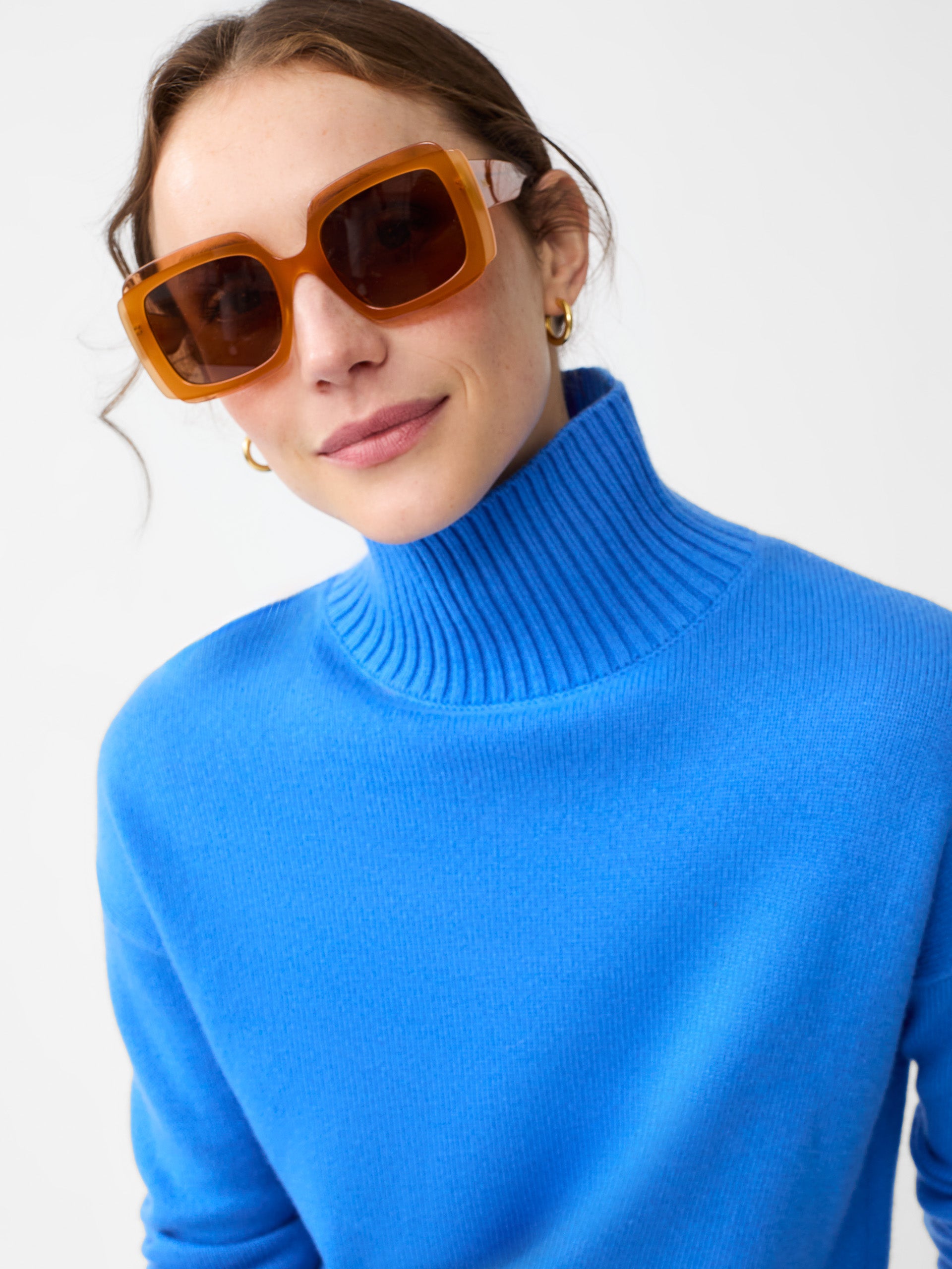 Model wearing J.McLaughlin Clara turtleneck in JMC blue made with cashmere.