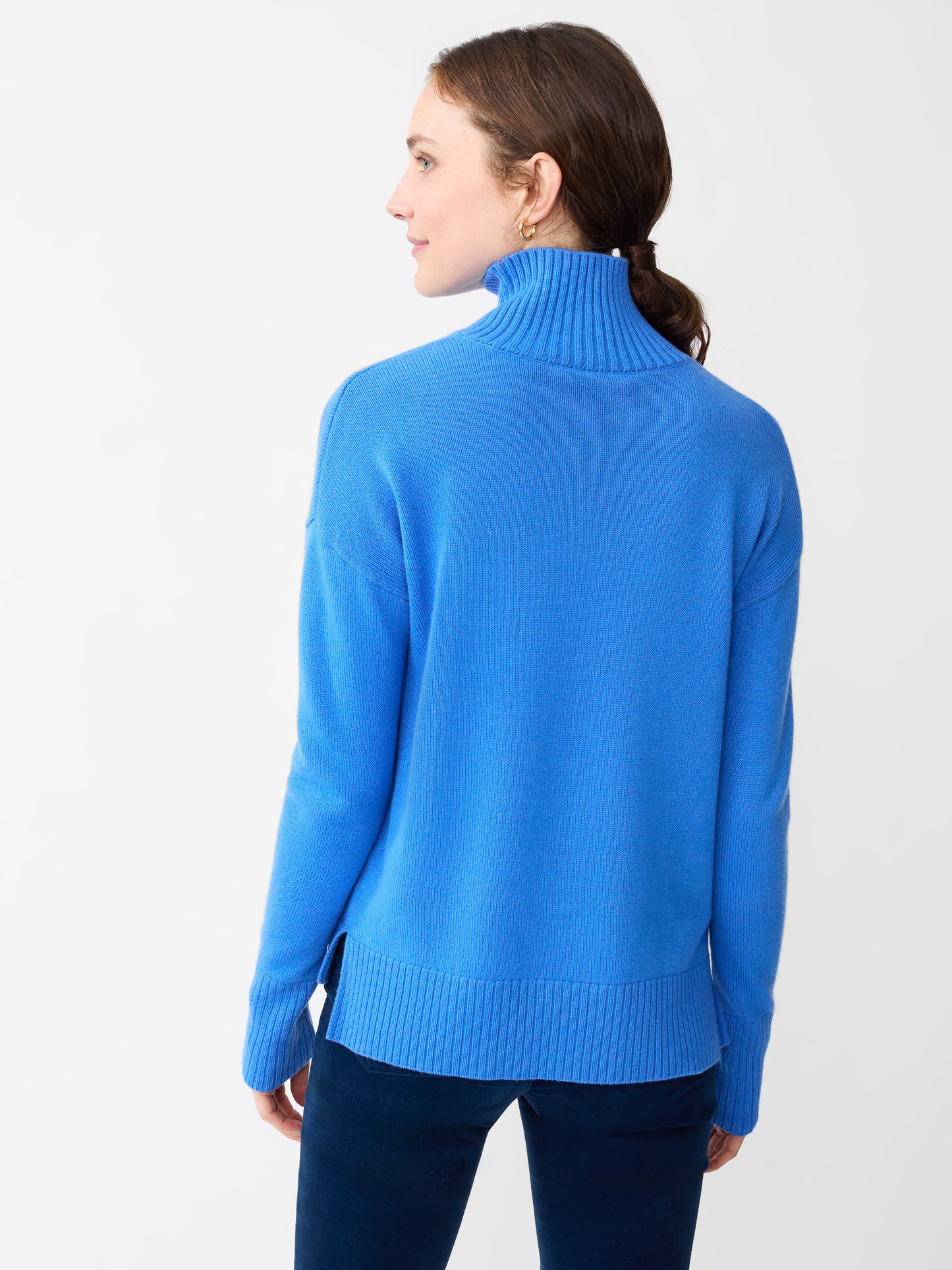 Model wearing J.McLaughlin Clara turtleneck in JMC blue made with cashmere.