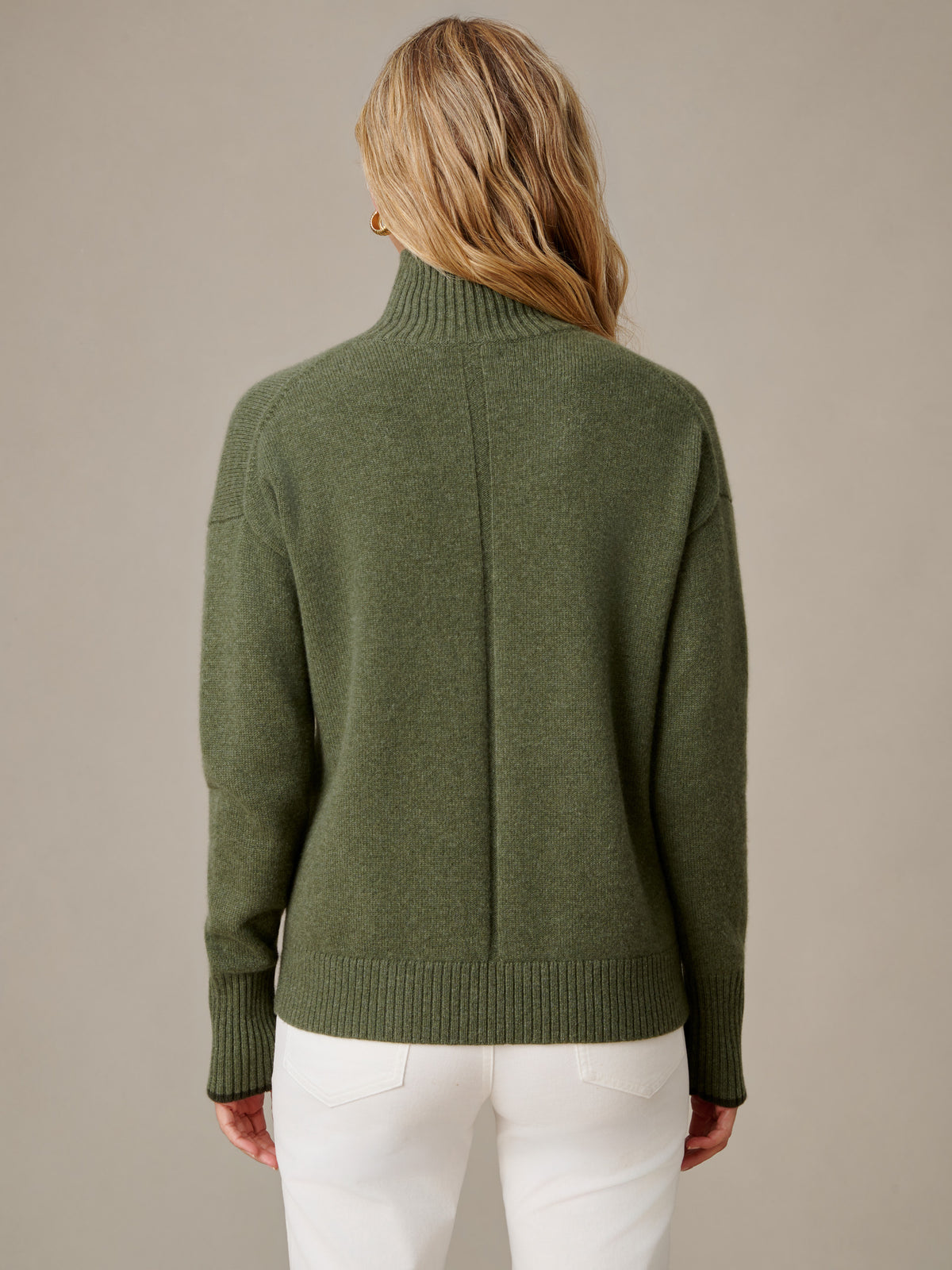 Dina Cashmere Turtleneck in olive green shown from the back with ribbed collar and cuffs paired with white pants by J.McLaughlin