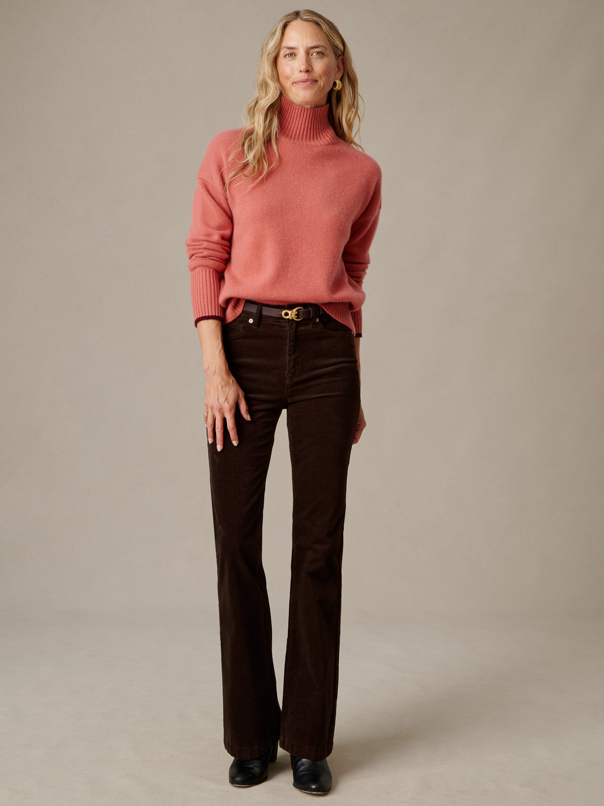 J.McLaughlin Dina Cashmere Turtleneck in rose pink with dark brown pants and black shoes modeled in a timeless casual look
