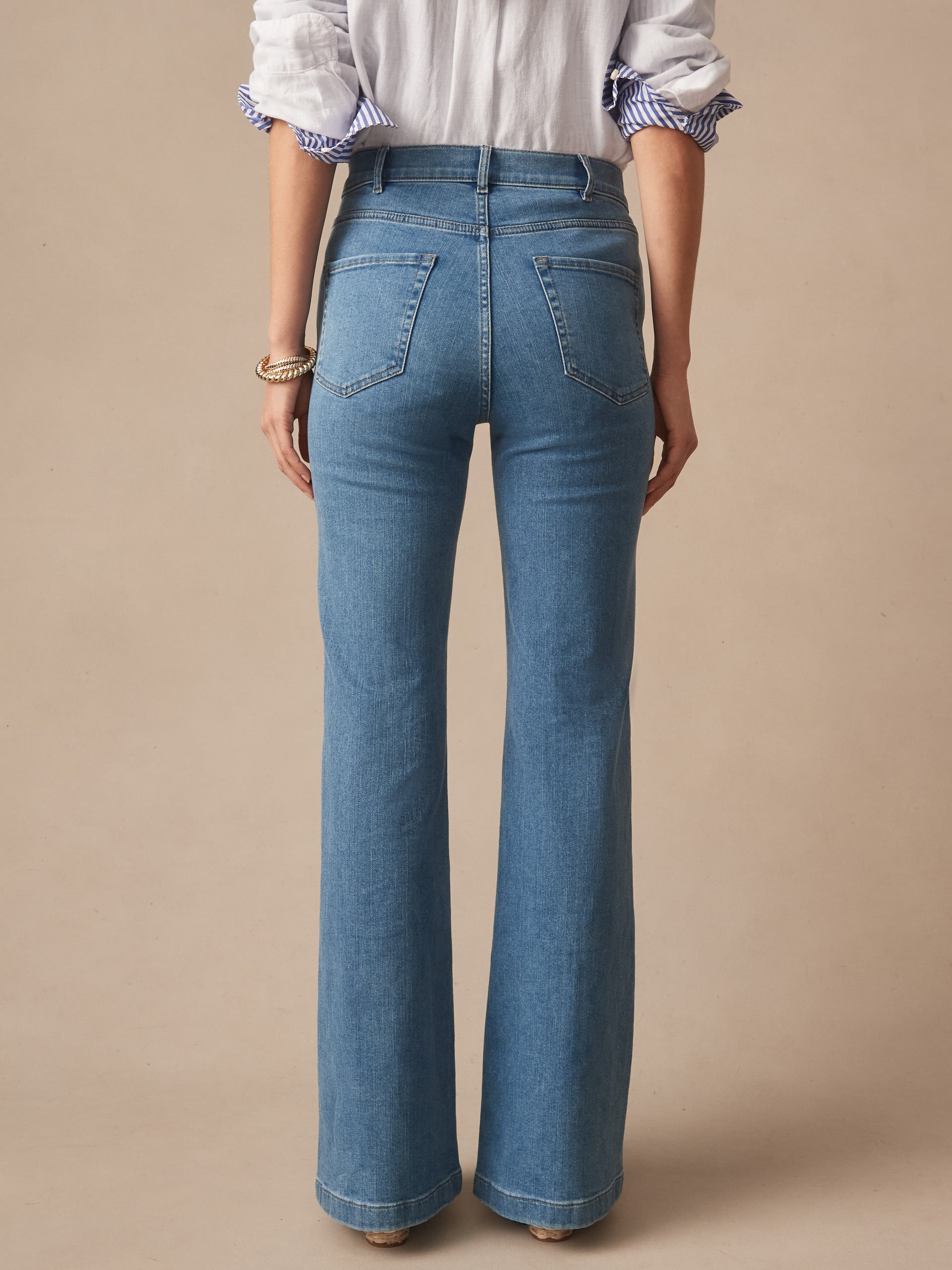 Back view of a woman wearing Domino Jeans by J.McLaughlin in classic blue denim, showcasing effortlessly stylish and enduring designs from a brand known for its legacy of timeless fashion.