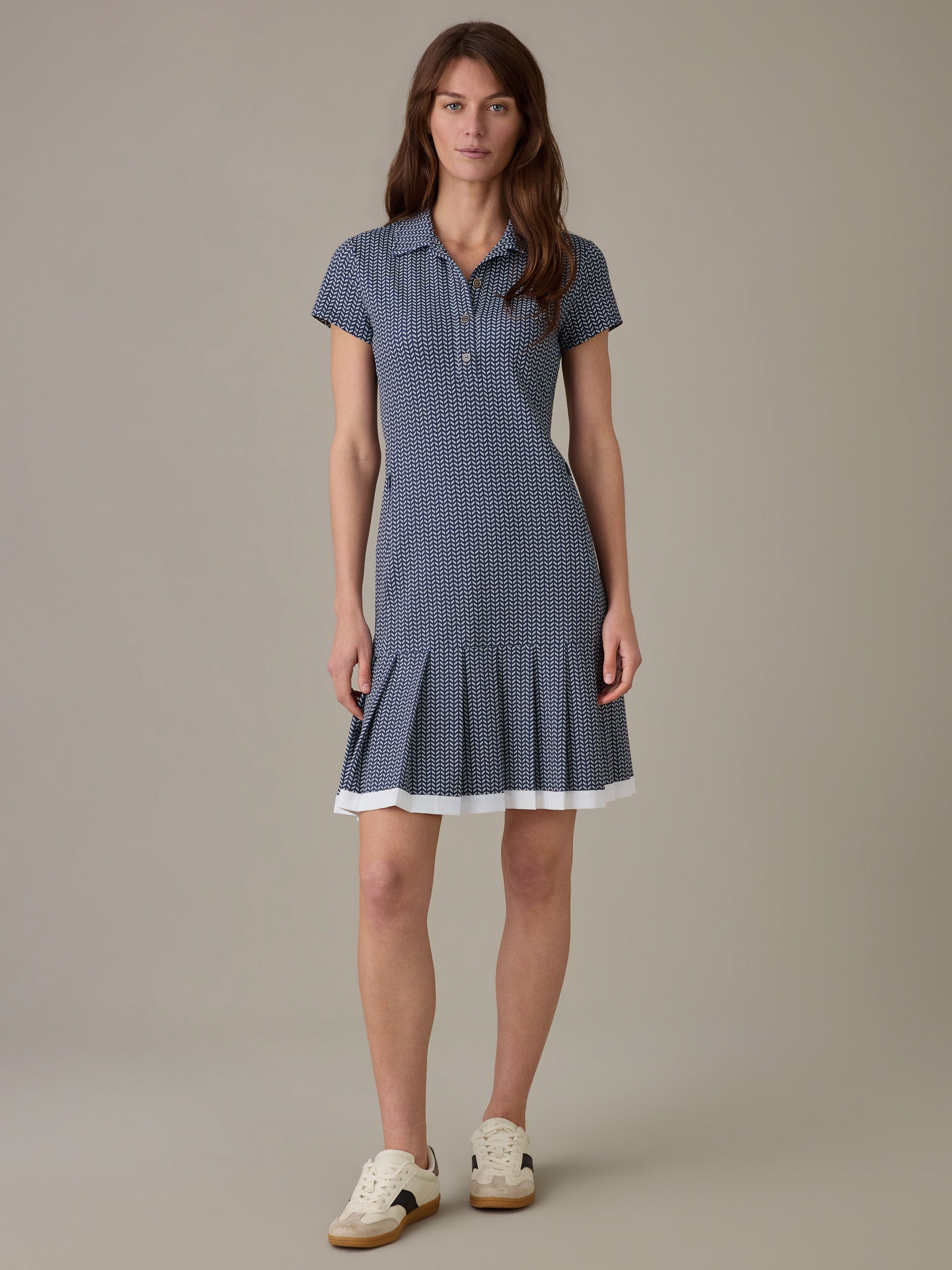 Woman wearing the Dorte Dress in Vine by J.McLaughlin, a classic, effortlessly stylish dress featuring a subtle pattern and pleated hem paired with casual sneakers.