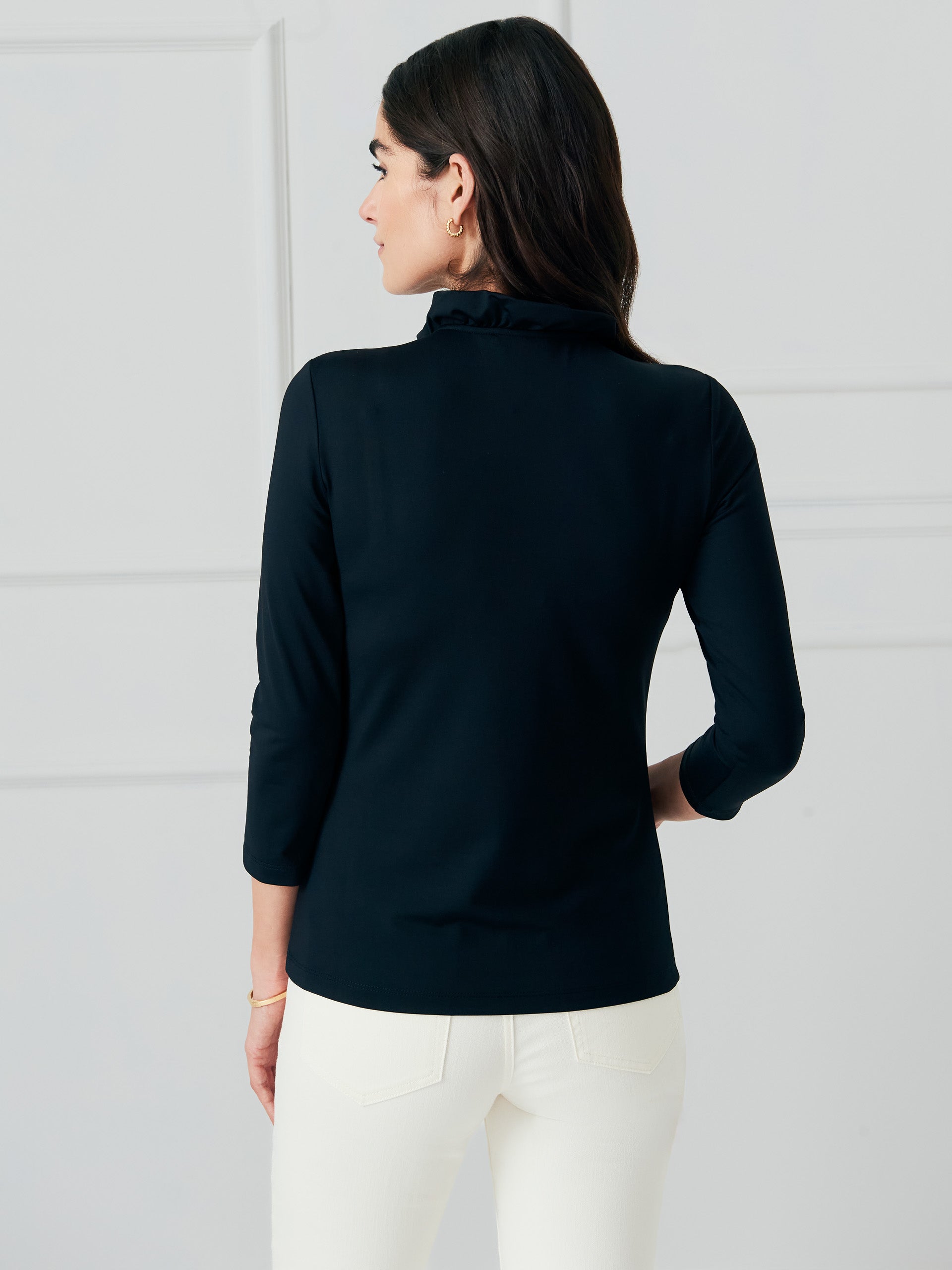 Model wearing J.McLaughlin Durham ruffle top in black made with Catalina cloth.