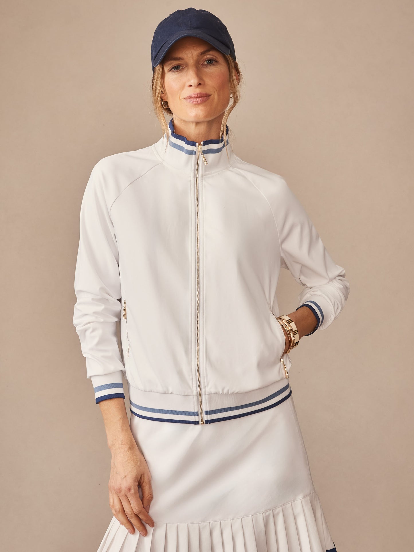 Woman wears J.McLaughlin Elettra Jacket in white with navy stripes, showcasing effortlessly stylish design and innovative fabrics, embodying enduring designs and timeless fashion.