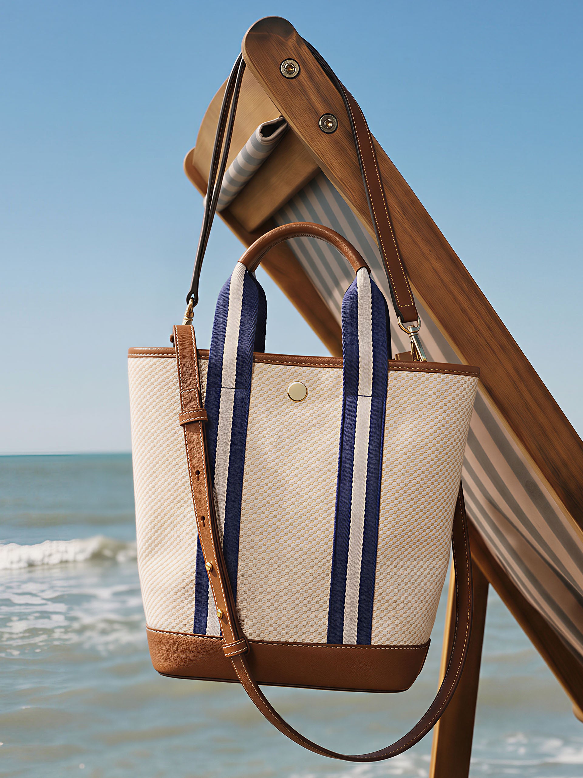 Emery Canvas Mini Tote by J.McLaughlin, effortlessly stylish with enduring designs and innovative fabrics, hanging on a wooden chair by the beach, a destination for defining style. Life, Well-Lived.