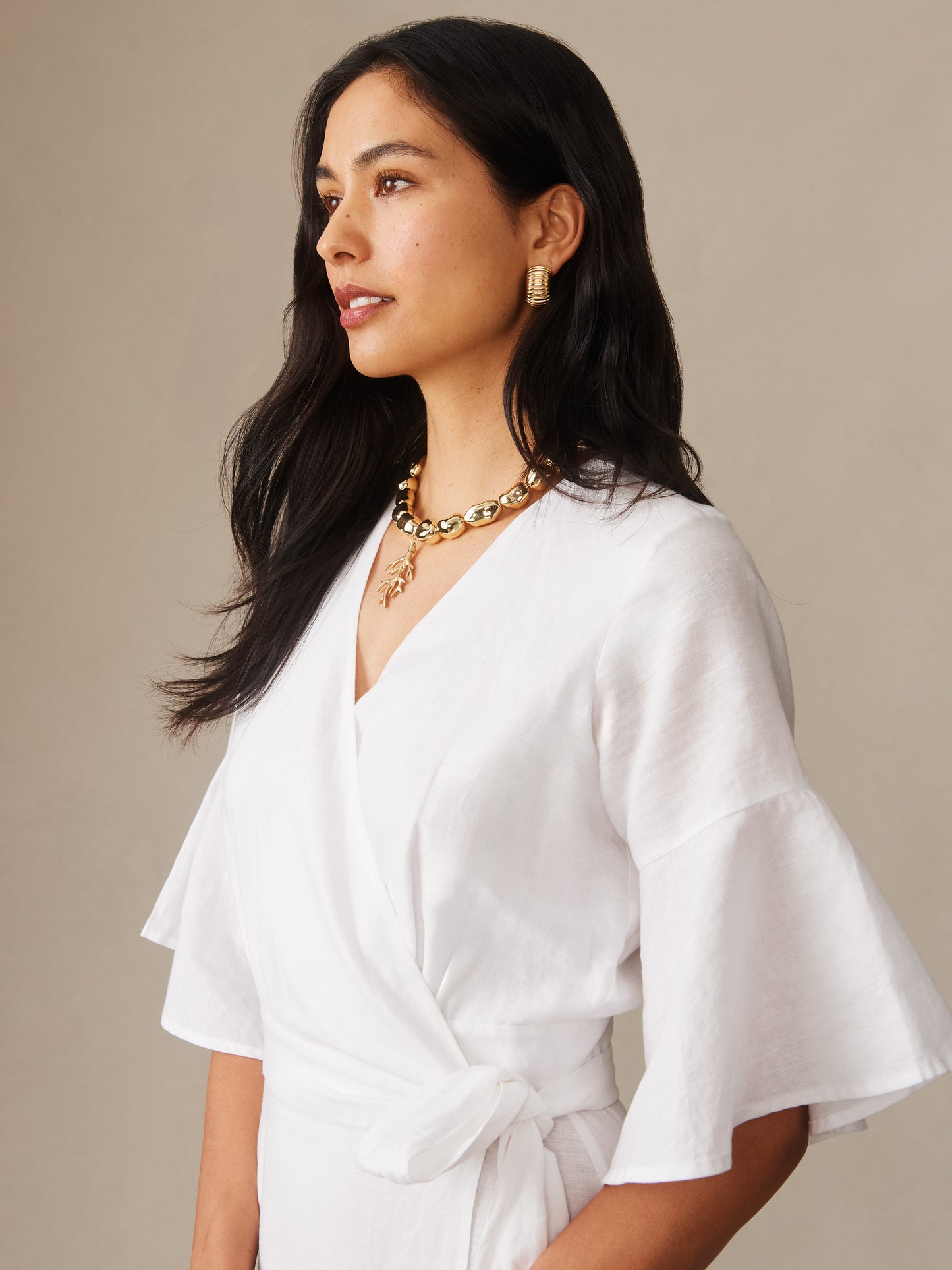 Elegant woman wearing the Emily Linen Blend Wrap Dress by J.McLaughlin, showcasing effortlessly stylish design and innovative fabrics in a timeless white wrap dress, embodying enduring designs and a legacy of timeless fashion at a destination for defining style. Life, Well-Lived.