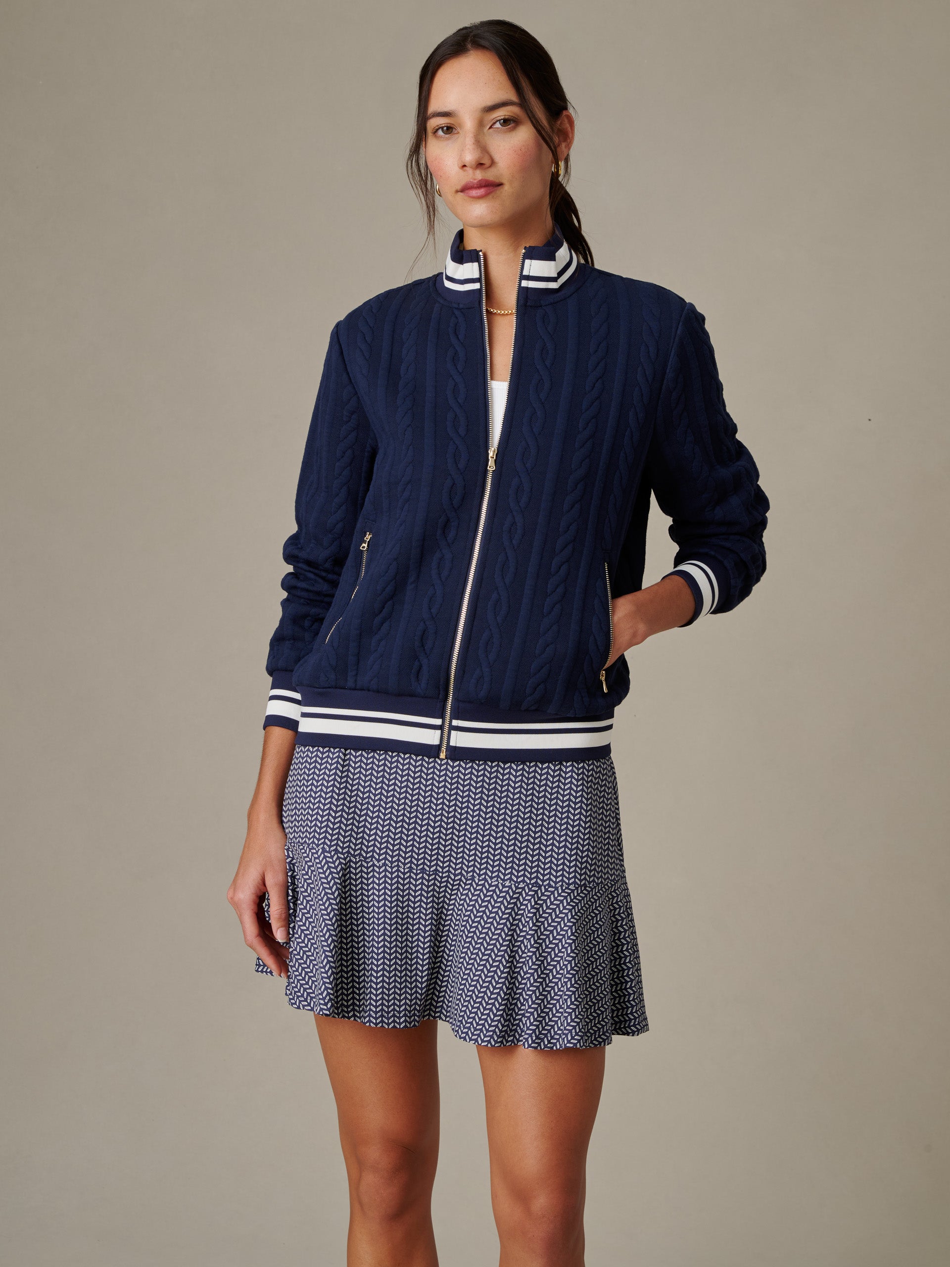 Woman wearing a navy Willa Jacket in Cable Jacquard by J.McLaughlin, styled with a patterned skirt, showcasing effortlessly stylish, enduring designs for a life well-lived.