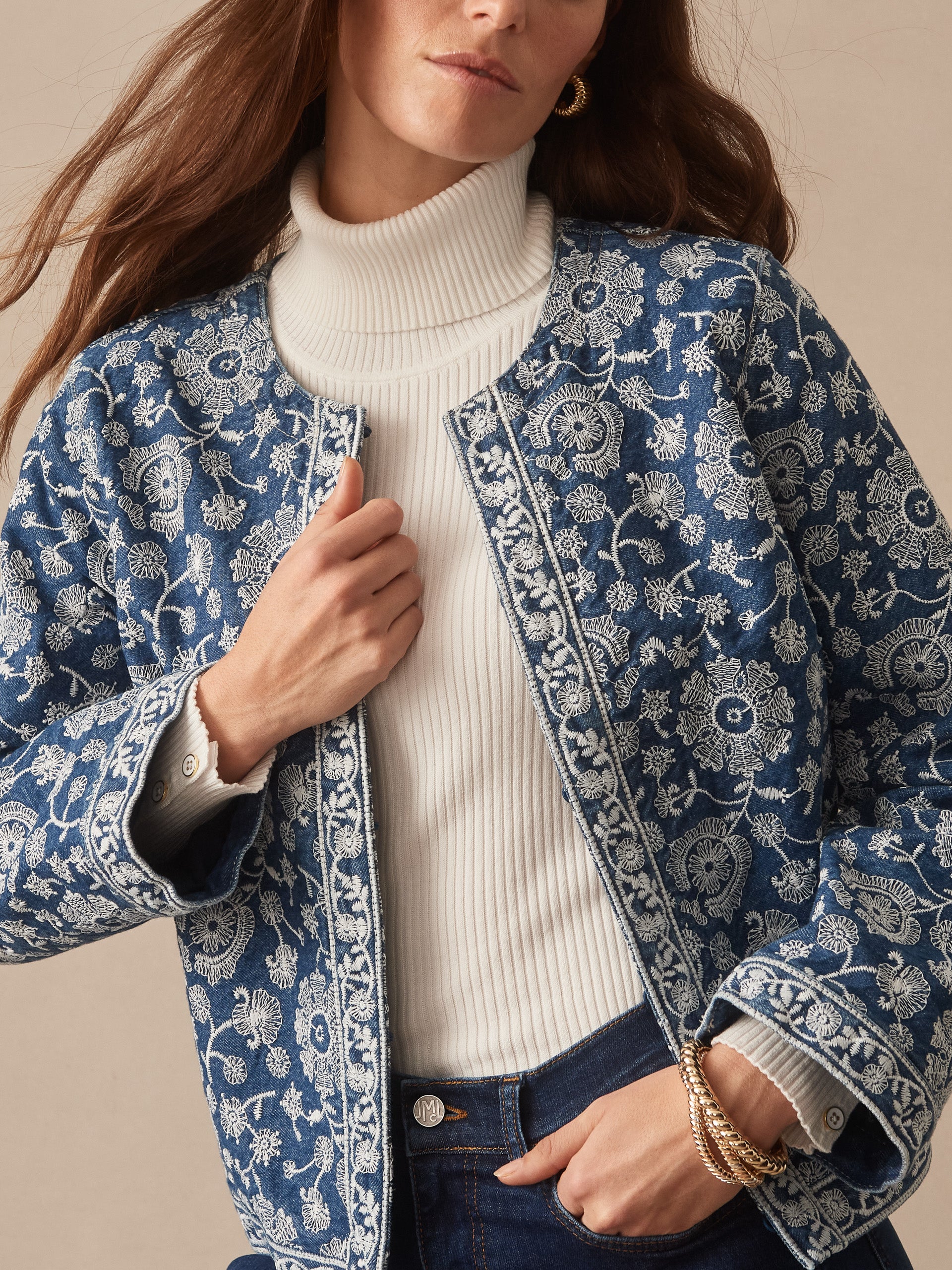 Woman wearing the Isabel Jacket in Floral Daydream Embroidery by J.McLaughlin over a white ribbed turtleneck, showcasing effortlessly stylish and enduring designs with innovative fabrics in a timeless look.