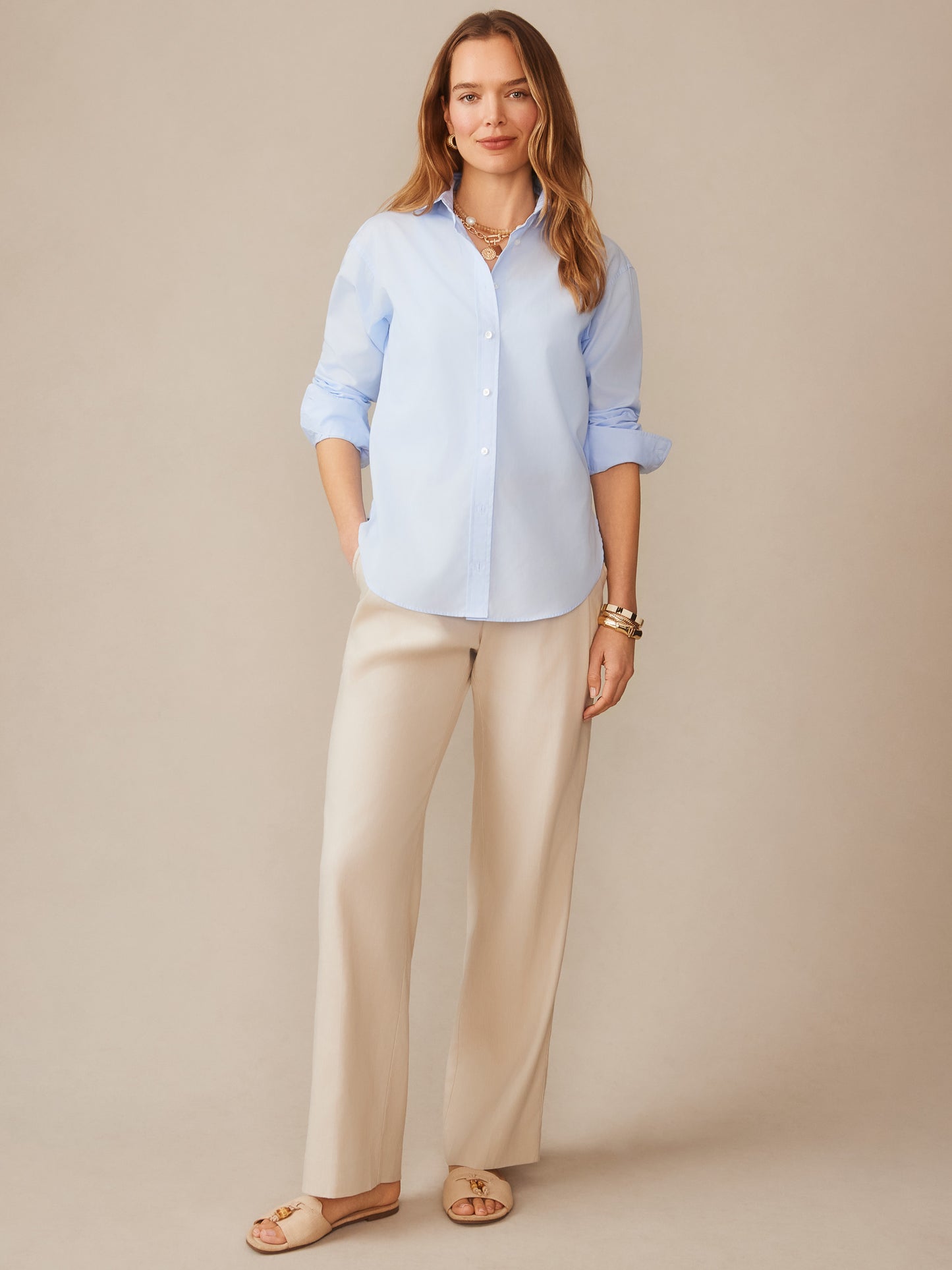 Woman wearing a light blue Finn Shirt by J.McLaughlin styled with beige wide-leg pants and sandals, showcasing effortlessly stylish, enduring designs and innovative fabrics.