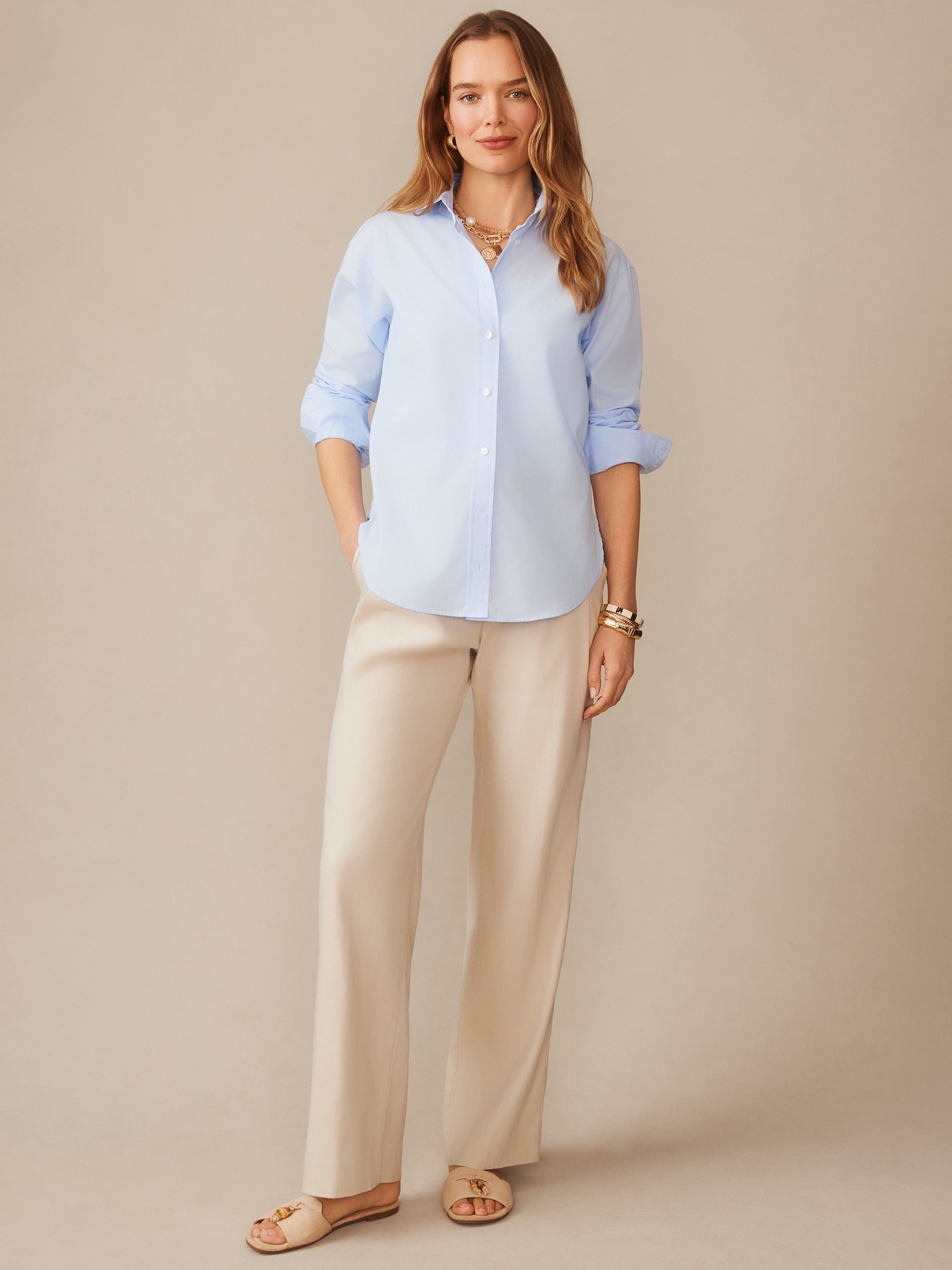Woman wearing a light blue Finn Shirt by J.McLaughlin styled with beige wide-leg pants and sandals, showcasing effortlessly stylish, enduring designs and innovative fabrics.