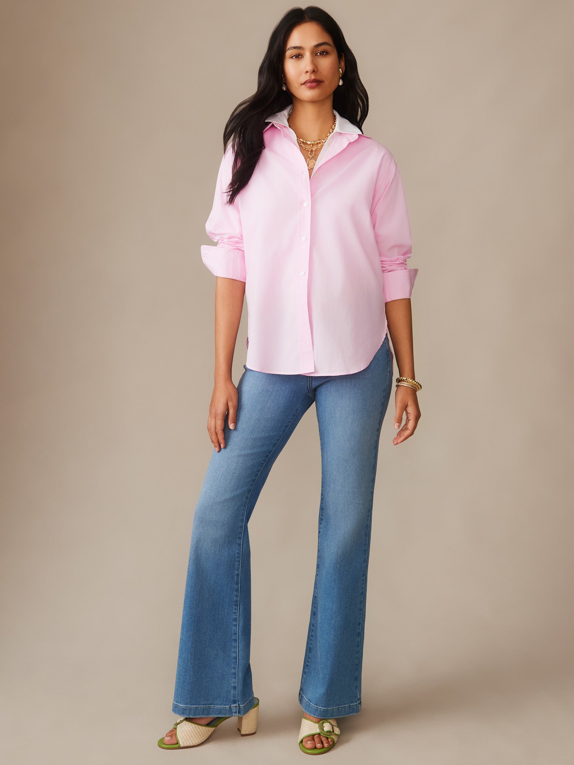 A woman wears a soft pink Finn Shirt by J.McLaughlin paired with blue jeans, showcasing effortlessly stylish, enduring designs in innovative fabrics, capturing a legacy of timeless fashion. A destination for defining style. Life, Well-Lived.