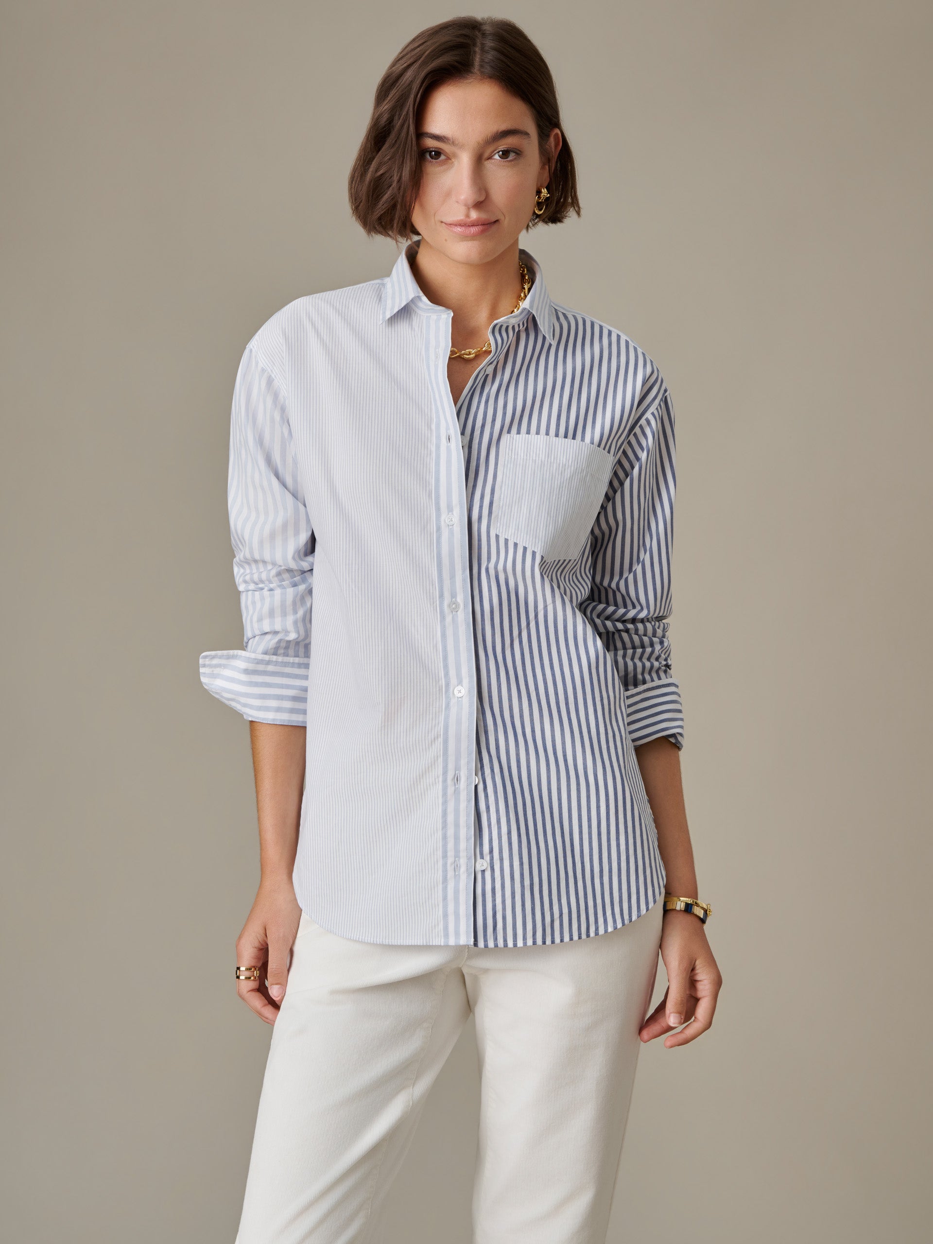 Woman wearing J.McLaughlin Finn Shirt in Stripe, featuring a two-tone vertical stripe design, paired with white pants in a timeless, effortlessly stylish look.
