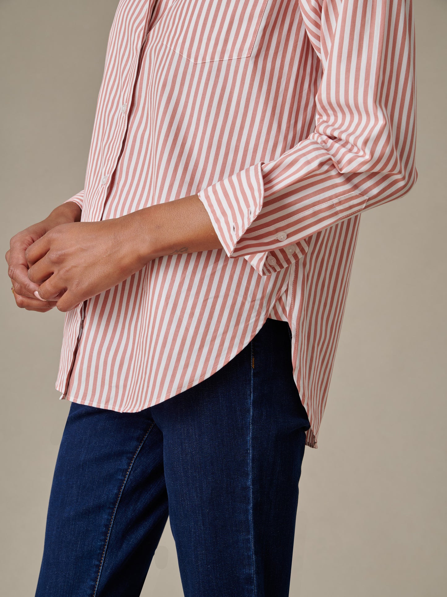 Side view of a person wearing a Finn Shirt in Stripe by J.McLaughlin, showcasing timeless striped design paired with dark denim jeans for an effortlessly stylish look.