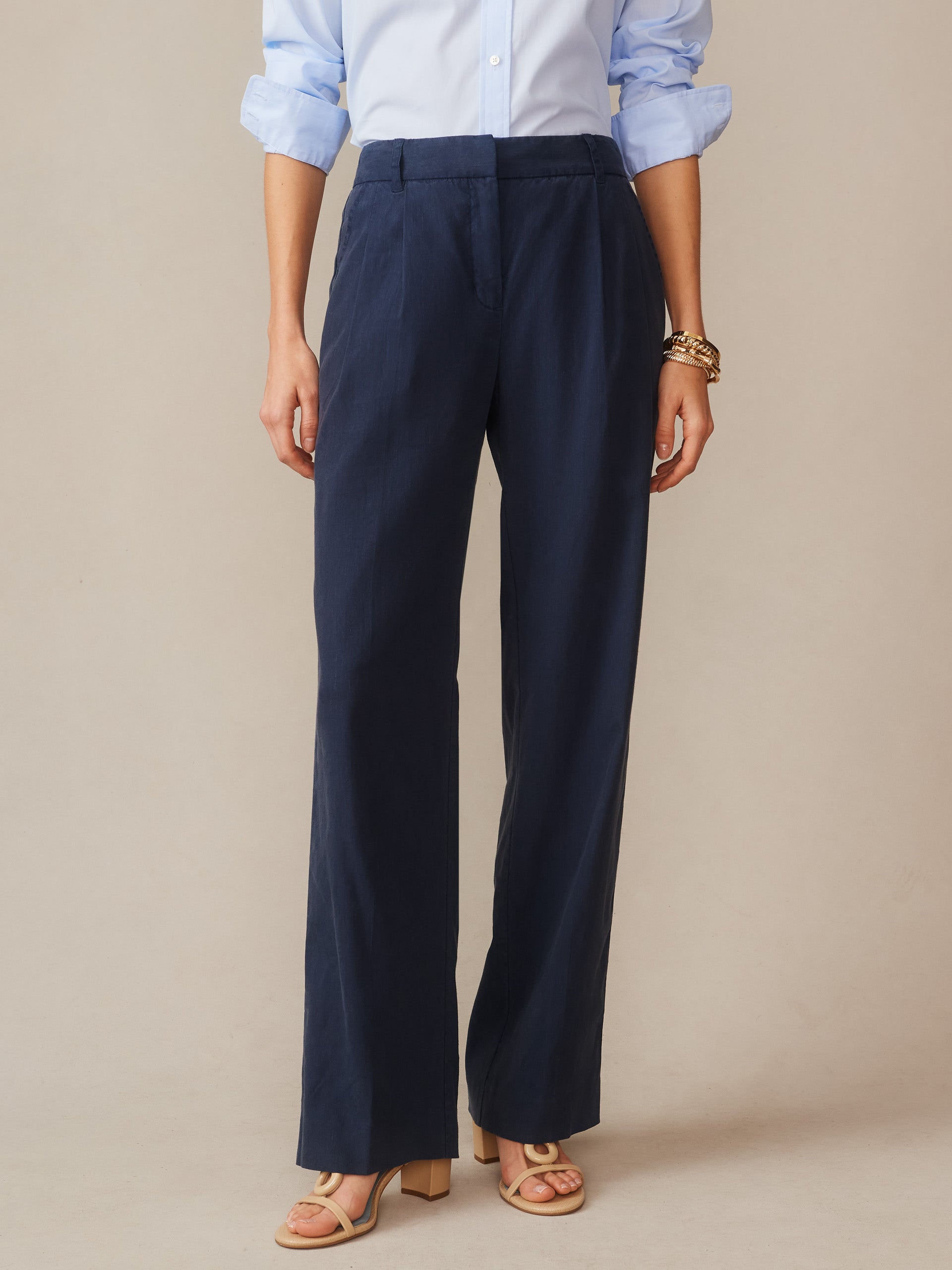 Woman wearing navy Fiona Linen Blend Pants by J.McLaughlin paired with a light blue shirt and sandals, showcasing effortlessly stylish, enduring designs with innovative fabrics.