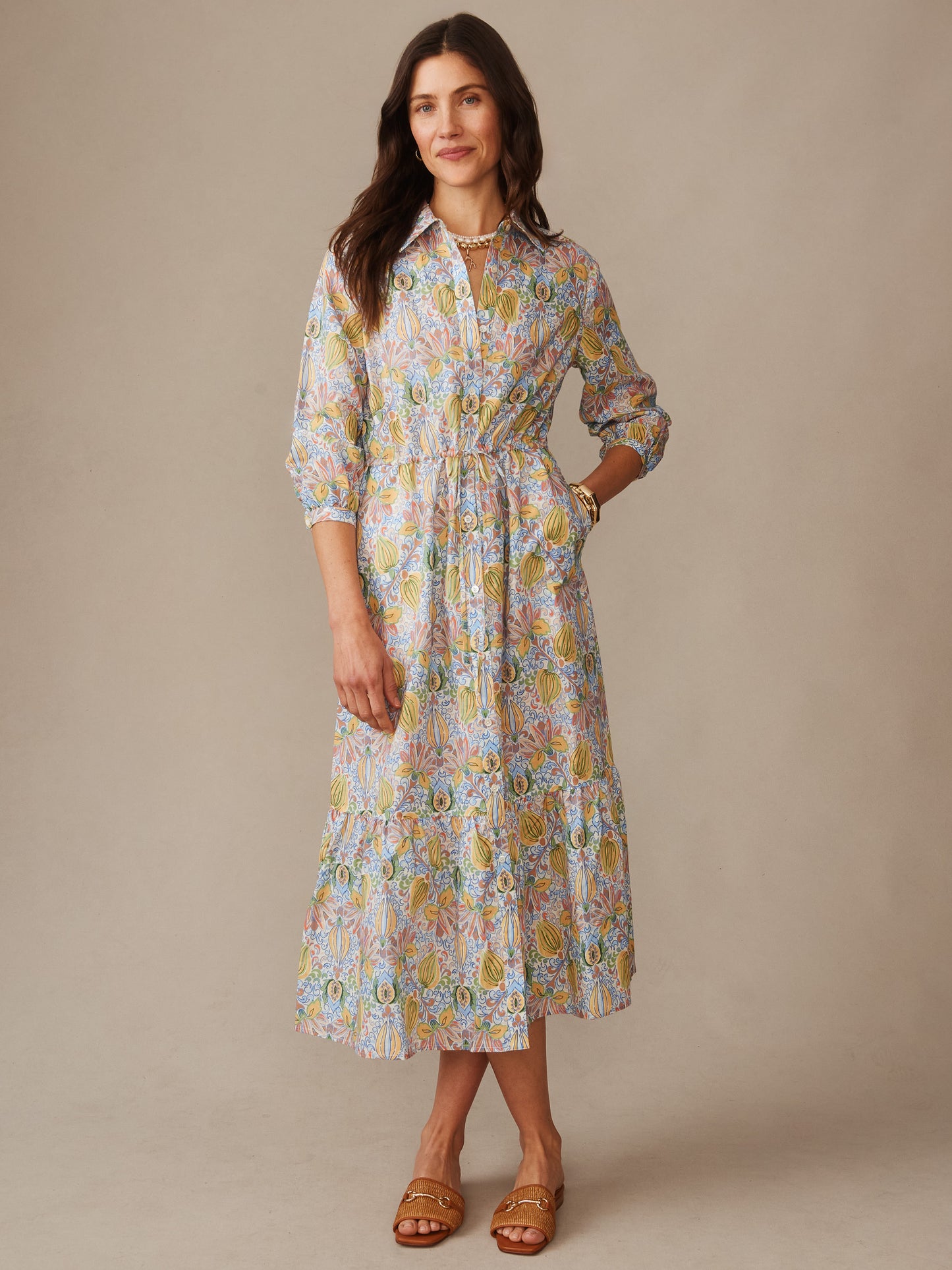 Woman wearing a Foley Linen Blend Dress in Tropico Tapestry by J.McLaughlin, featuring a colorful floral pattern, three-quarter sleeves, collared neckline, and a mid-length hem, styled with sandals. Effortlessly stylish, enduring designs crafted with innovative fabrics in a legacy of timeless fashion. A destination for defining style. Life, Well-Lived.