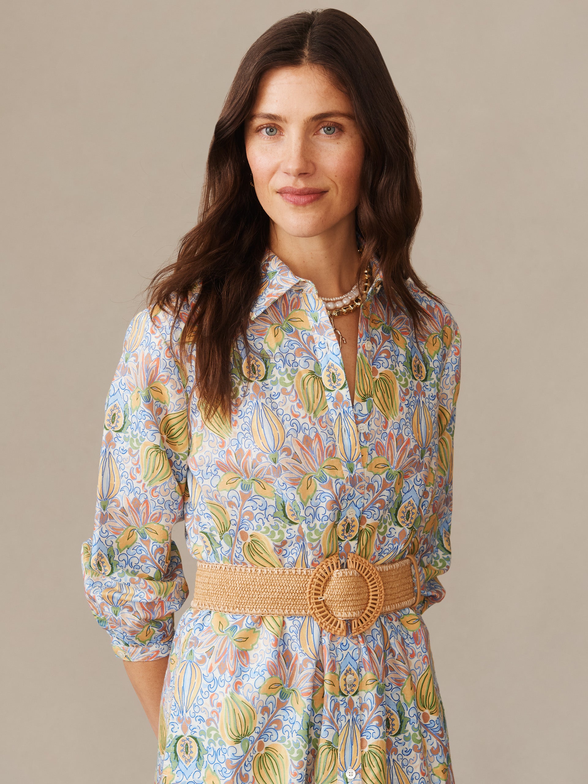A woman wearing the Foley Linen Blend Dress in Tropico Tapestry by J.McLaughlin, featuring a colorful floral pattern and a woven belt, showcasing effortlessly stylish, enduring designs with innovative fabrics and a legacy of timeless fashion. A destination for defining style. Life, Well-Lived.