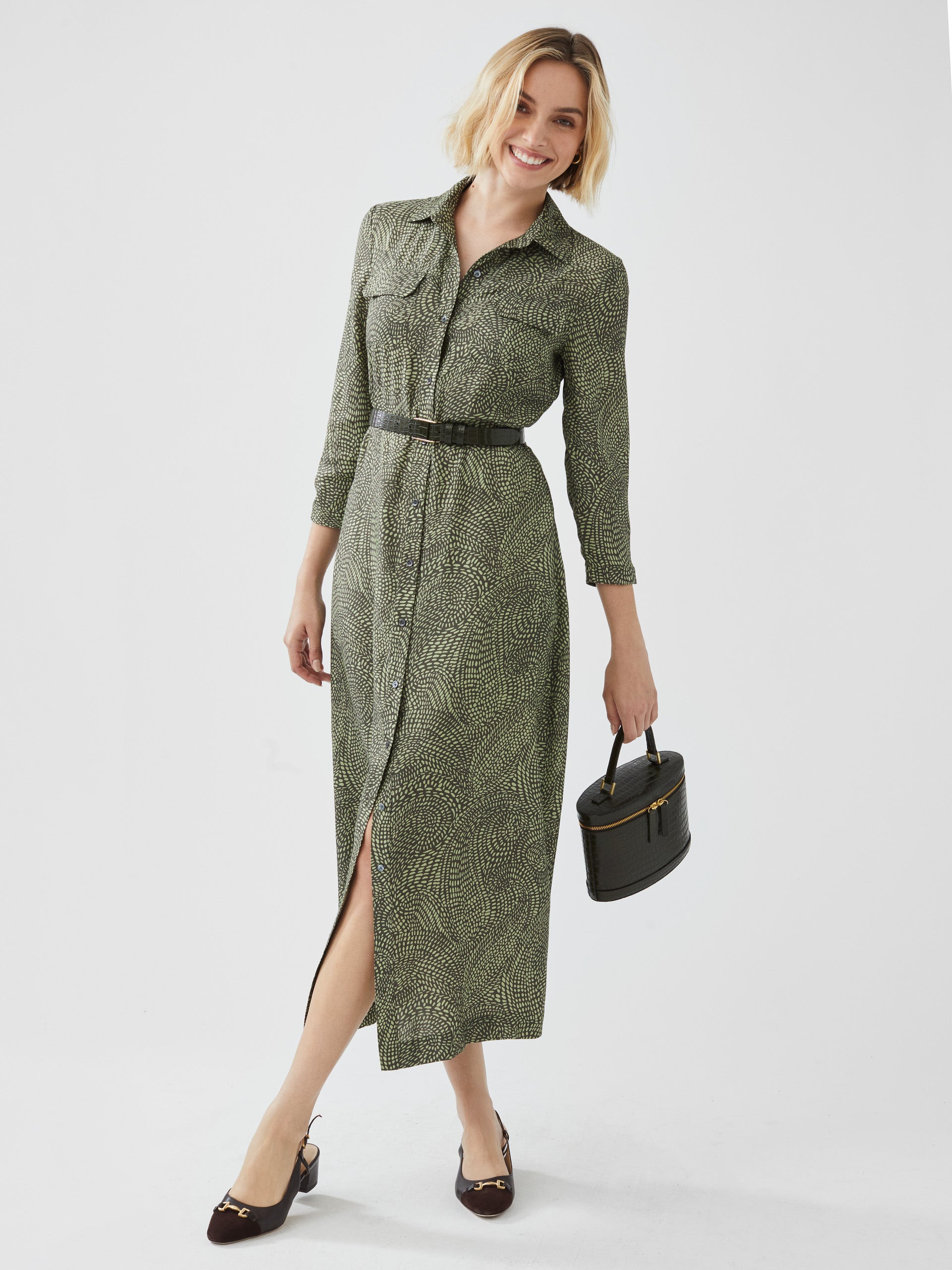 Model wearing J.McLaughlin Freda dress in olive/green made with viscose and silk.