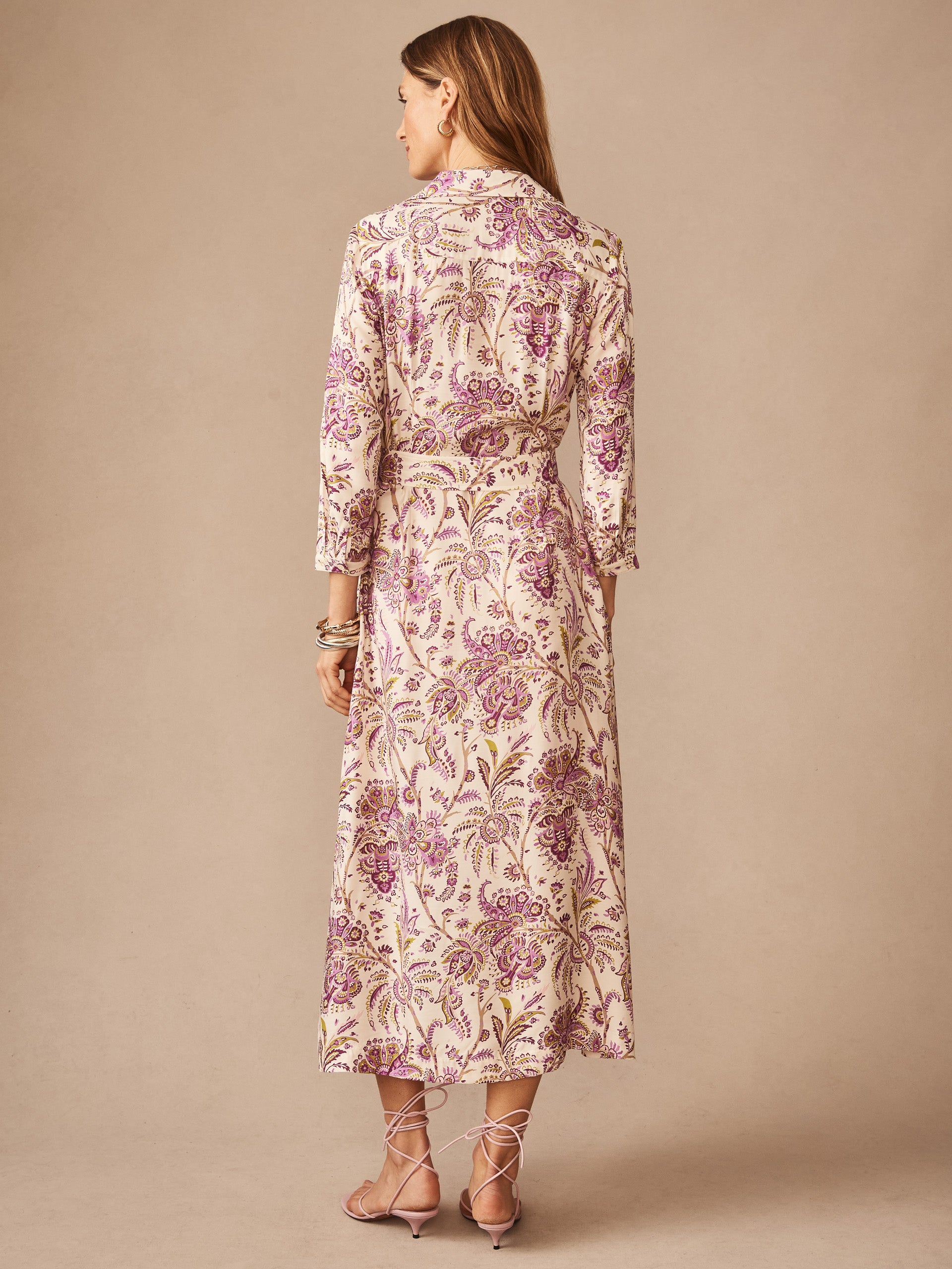 Woman wearing a Freda Dress in Maxi Heirloom Paisley by J.McLaughlin, featuring a flowing maxi silhouette with elegant purple floral patterns, embodying effortlessly stylish, enduring designs and innovative fabrics. A destination for defining style. Life, Well-Lived.
