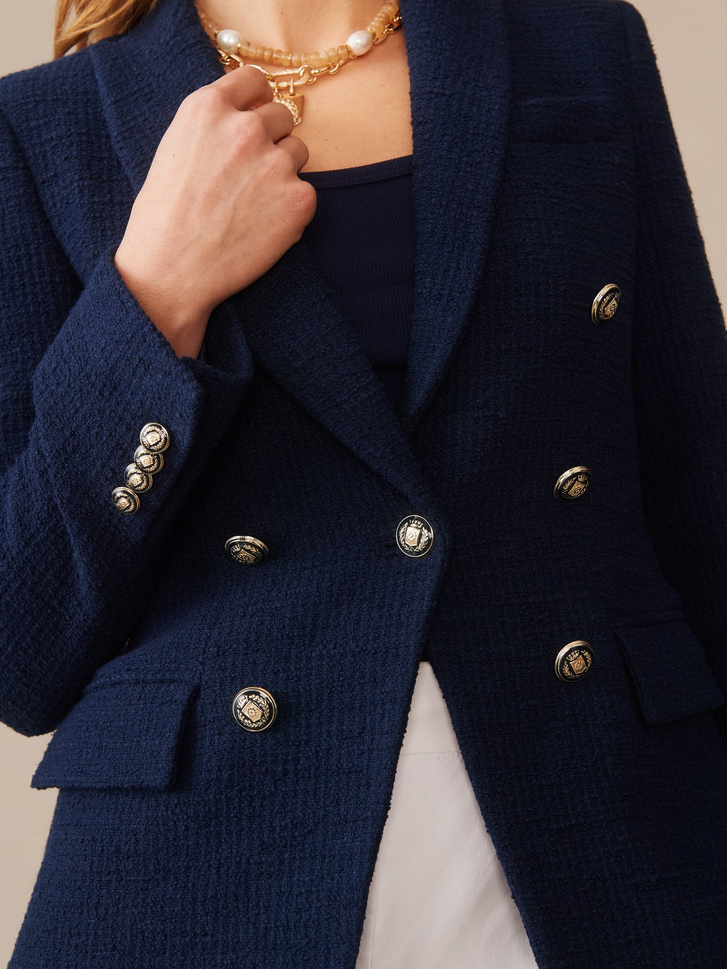 Close-up of a navy Genevieve Cotton Bouclé Blazer by J.McLaughlin featuring textured fabric, gold-tone buttons, and a classic silhouette, embodying effortlessly stylish, enduring designs and innovative fabrics for a destination for defining style. Life, Well-Lived.