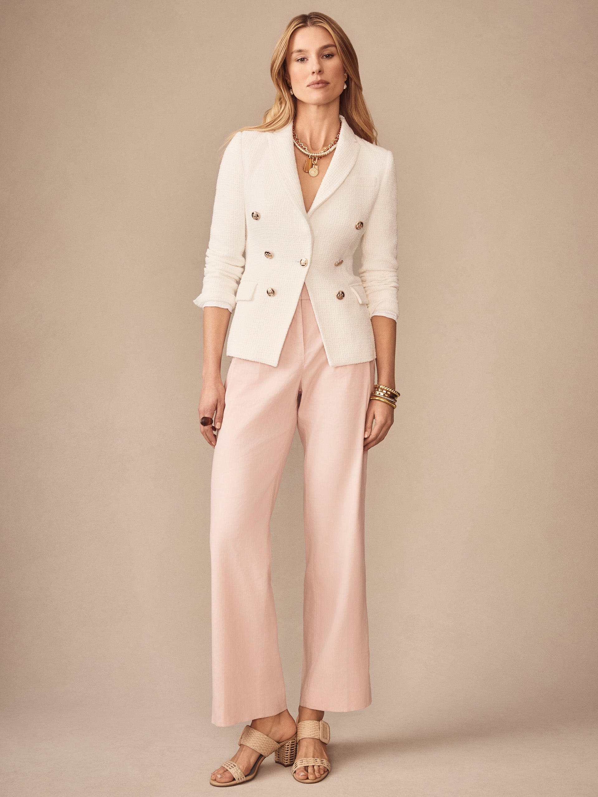 A stylish woman wearing the Genevieve Cotton Bouclé Blazer by J.McLaughlin, paired with soft pink wide-leg pants and neutral heels, showcasing effortlessly stylish, enduring designs and innovative fabrics from a destination for defining style. Life, Well-Lived.