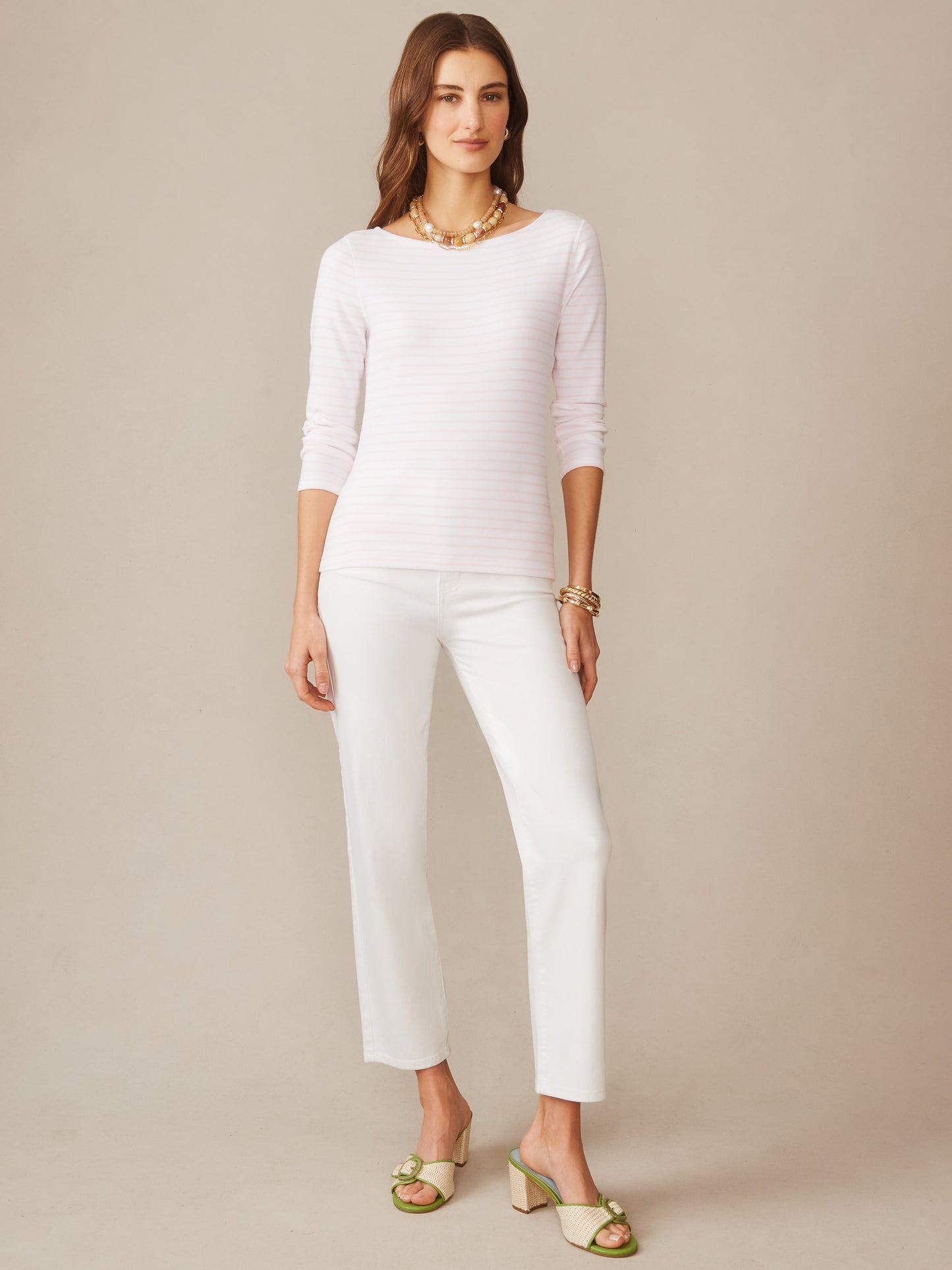 A woman wearing the Goldie Tee in Stripe by J.McLaughlin paired with white pants and stylish sandals, embodying effortlessly stylish, enduring designs with a legacy of timeless fashion. A destination for defining style. Life, Well-Lived.