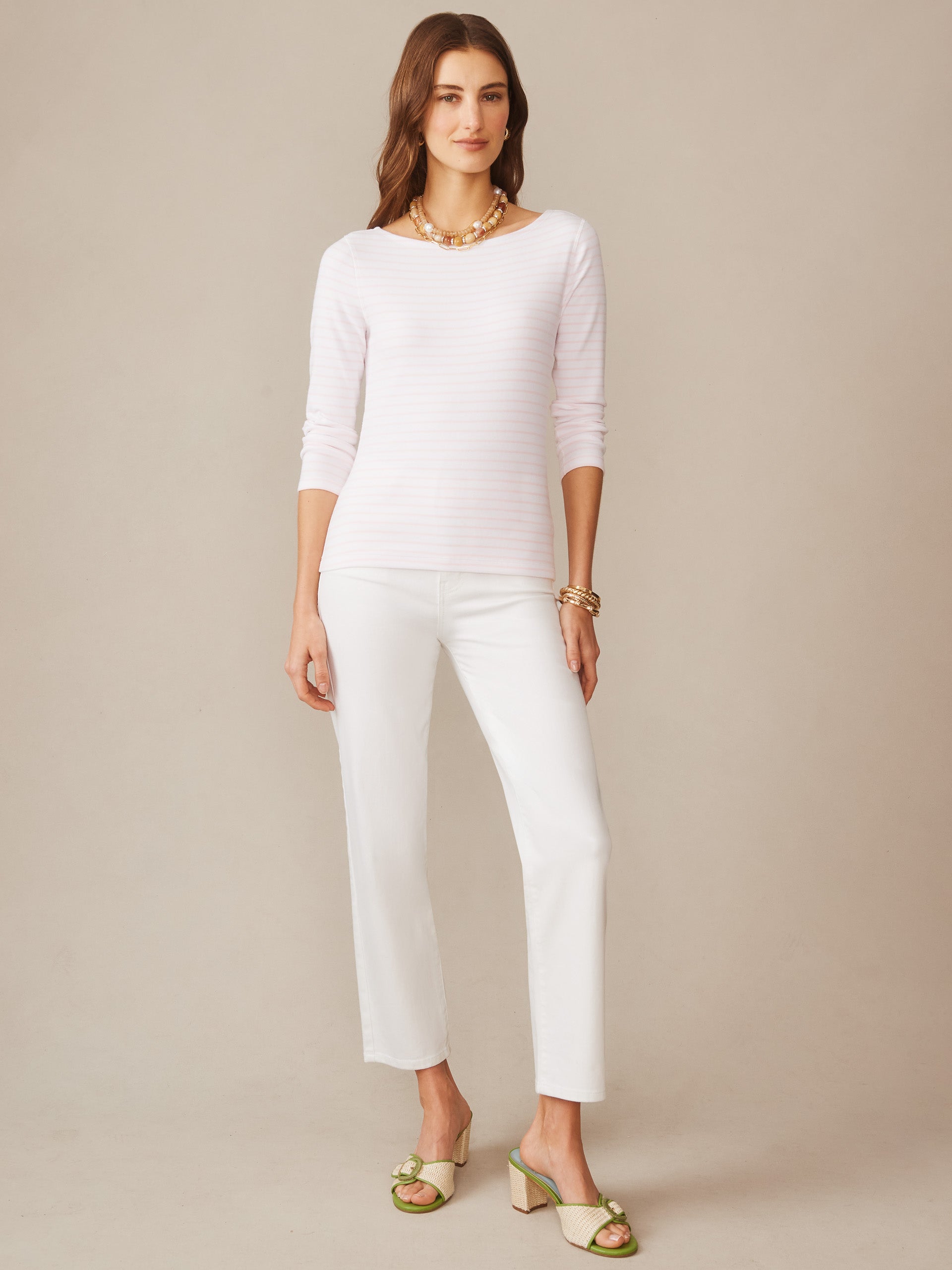 A woman wearing the Goldie Tee in Stripe by J.McLaughlin paired with white pants and stylish sandals, embodying effortlessly stylish, enduring designs with a legacy of timeless fashion. A destination for defining style. Life, Well-Lived.
